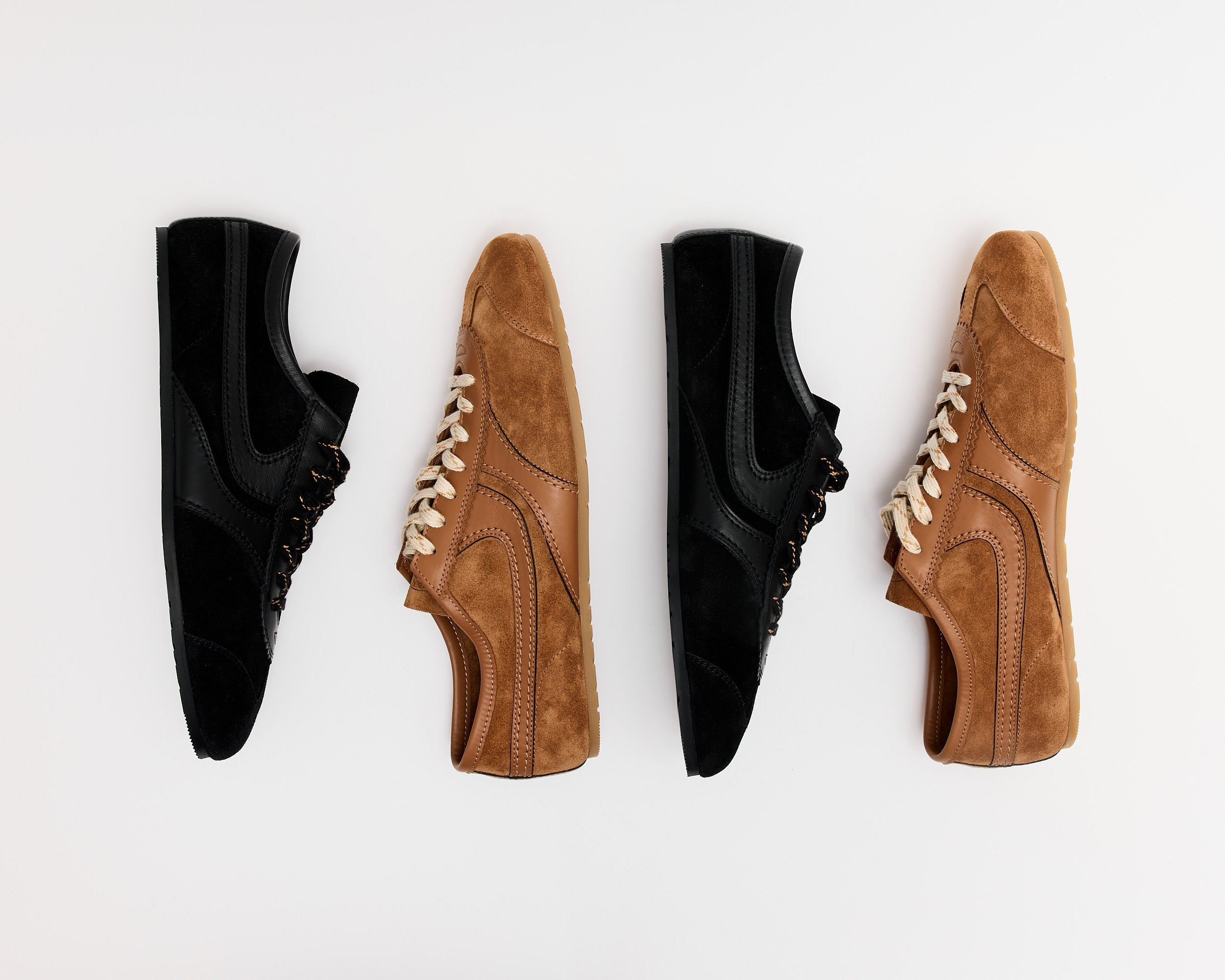 Five pairs of shoes, including ankle boots and Mary Janes in black, brown, white, and metallic silver, arranged in a semi-circle on a plain light background.