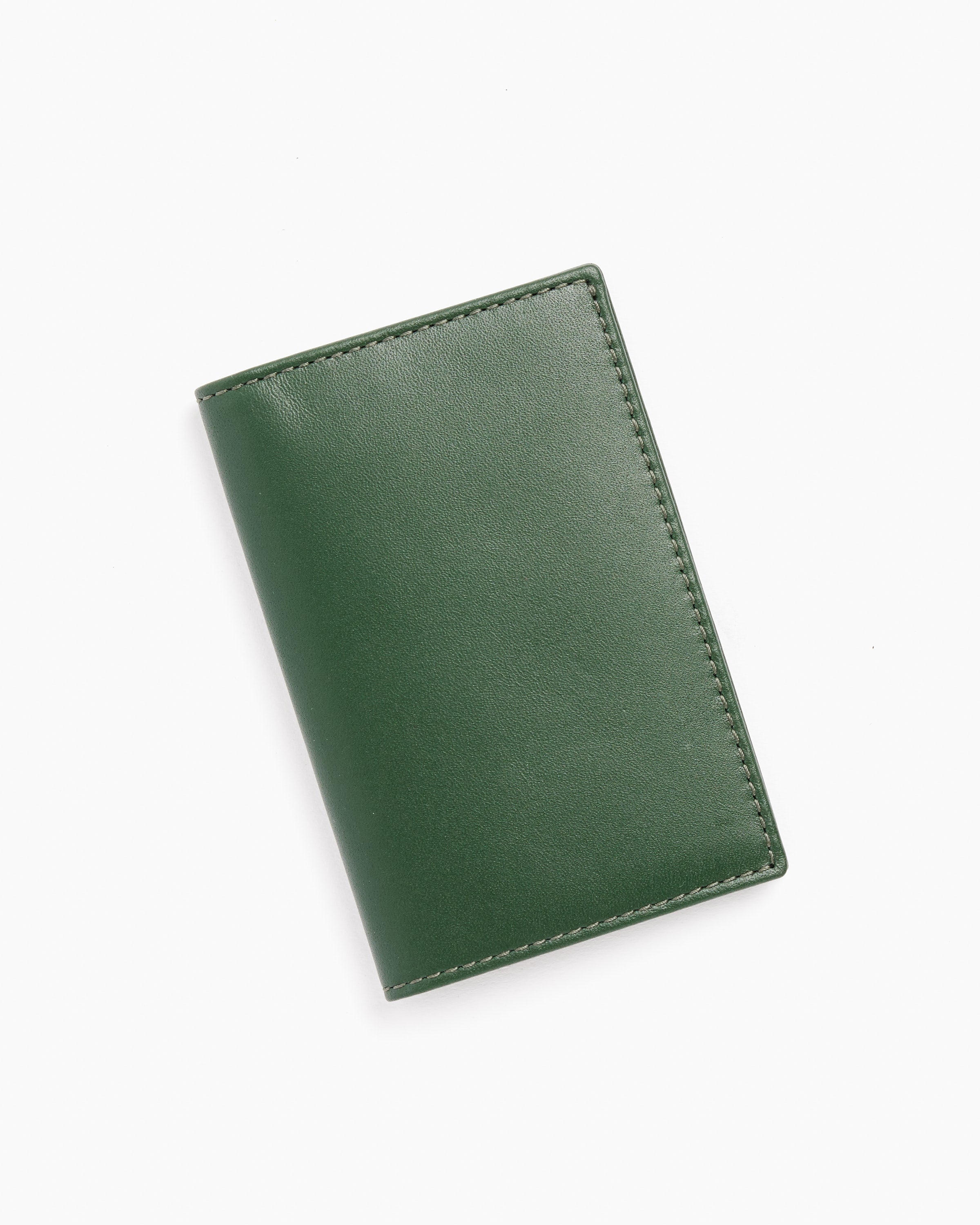 The Classic Cardholder in Bottle Green by Comme des Garcons Wallet features closed cowhide leather with visible edge stitching, shown on a plain white background.