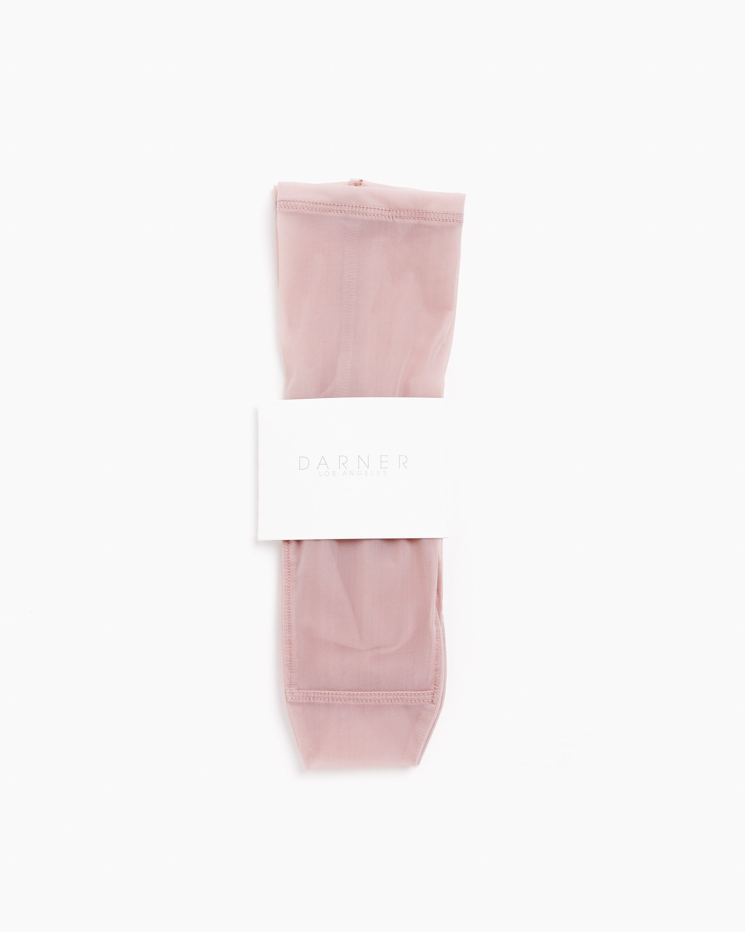 A pair of Solid Mesh Socks in Blush by Darner, neatly folded and wrapped with a white paper band showing the brand name, set against a plain white background.