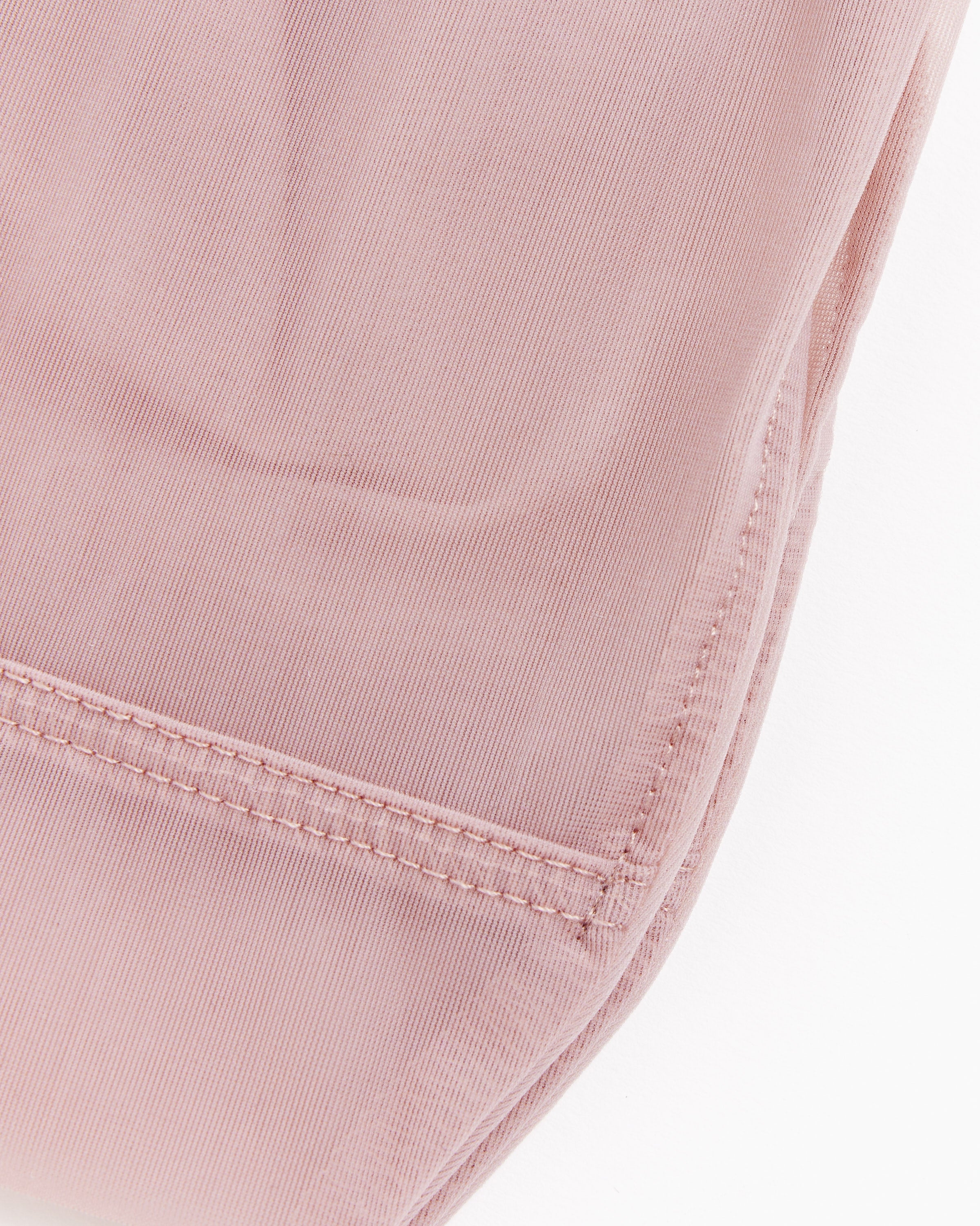 Close-up of the hem and seam of pink pants, highlighting fabric texture and detailed stitching, paired with Darner Solid Mesh Socks in Blush.
