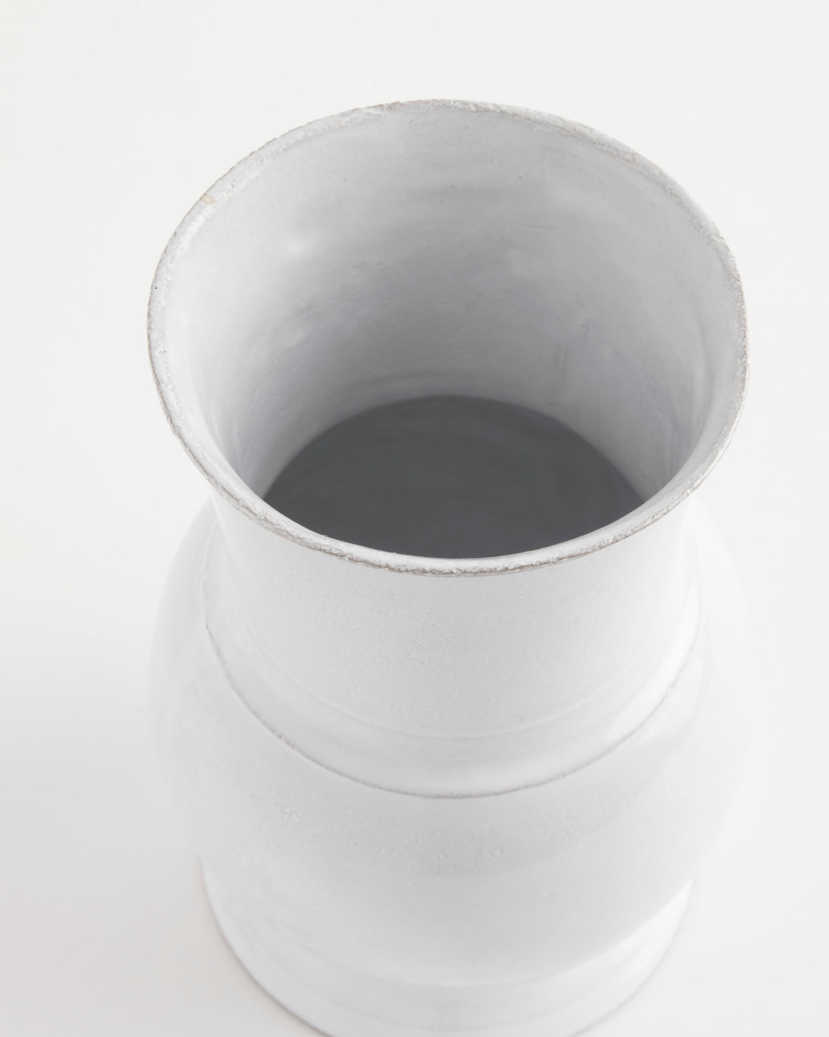 A top-down view of the Astier de Villatte Colbert Vase—a handmade, plain white ceramic piece from France featuring a wide opening—set against a white background.