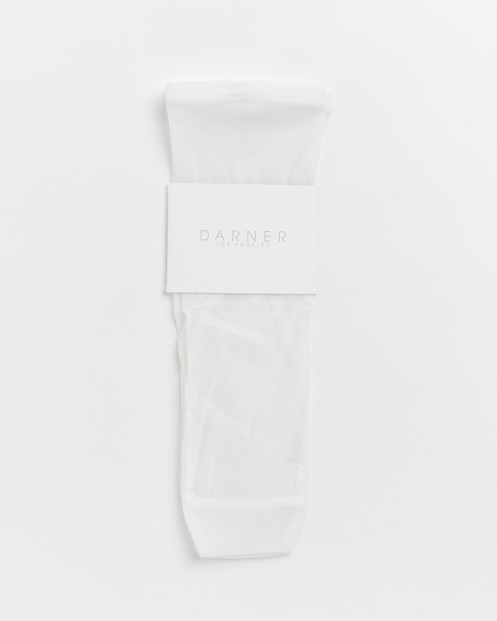 A pair of Darner Solid Mesh Socks in White, neatly folded and secured with a branded paper band, made in Los Angeles and displayed on a crisp white background.