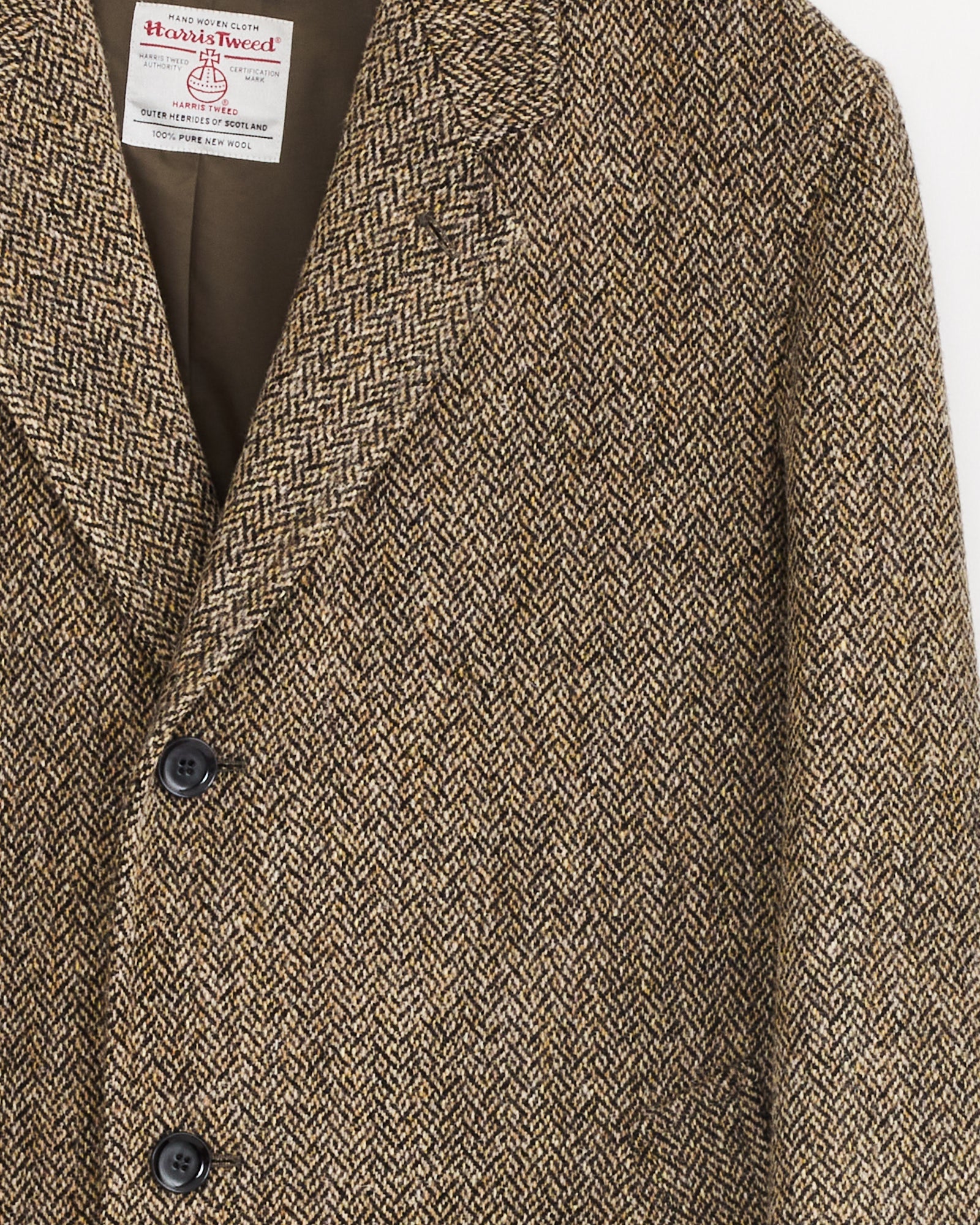 Close-up of the Chesterfield Coat in Black/Straw Melange by Lemaire, featuring detailed, textured fabric and a visible collar label that highlights the coat’s timeless elegance.