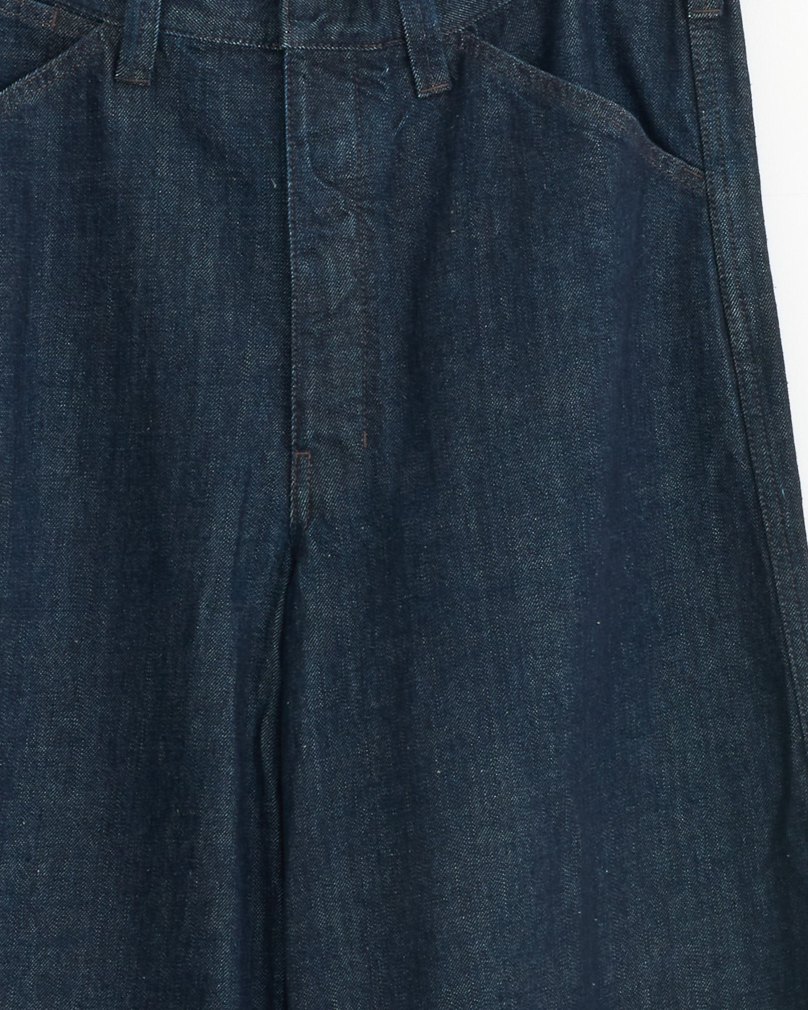 Close-up of the upper section of the Lemaire Maxi Workwear Pant in Denim Indigo, highlighting the waistband, belt loops, front pockets, and fly with detailed visible stitching.