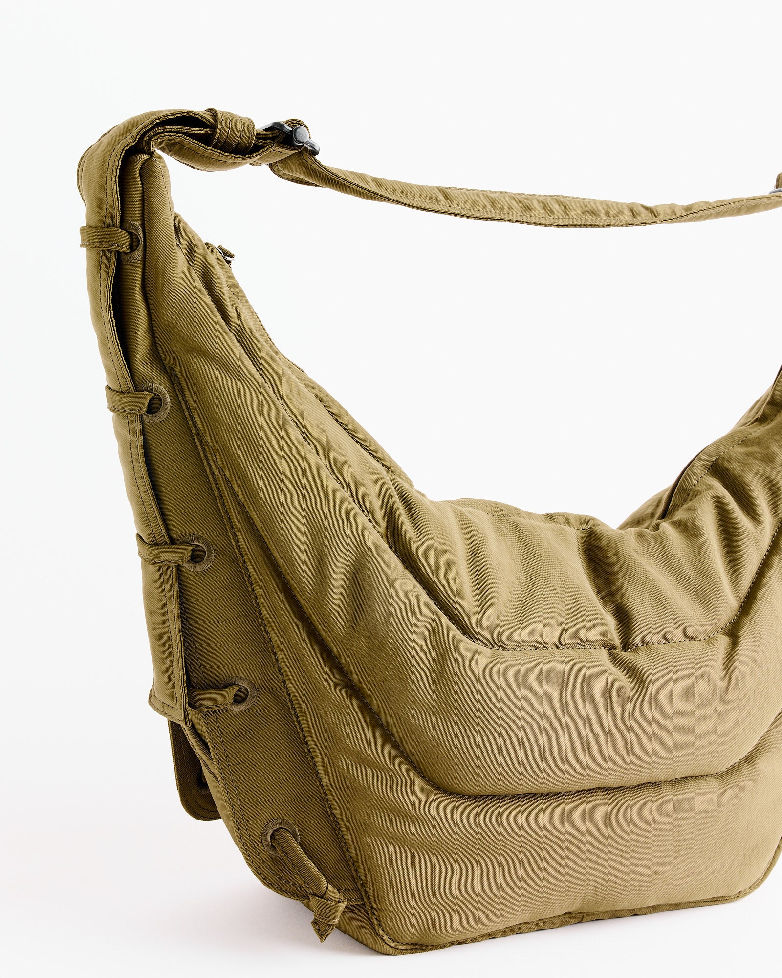 The Medium Soft Game Bag in Dusty Khaki by Lemaire, made from water-repellent nylon, features padded shoulders, a thick strap, and side lacing detail. Photographed against a plain white background.