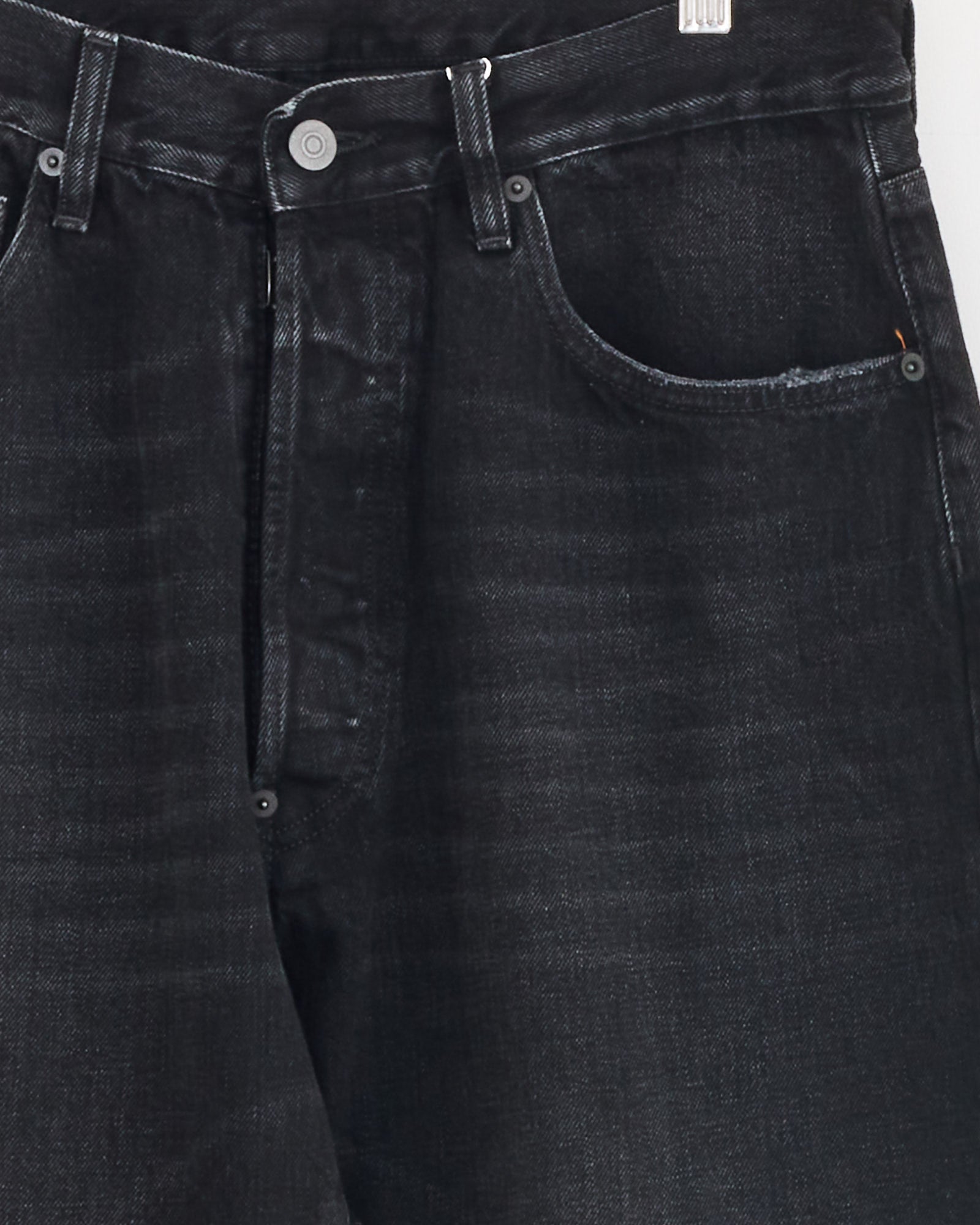 Close-up of the upper section of Maison Margiela's 5 Pocket Pant in Black, featuring straight leg cotton denim with a slightly faded finish, waistband, button closure, front pockets, and visible stitching details.