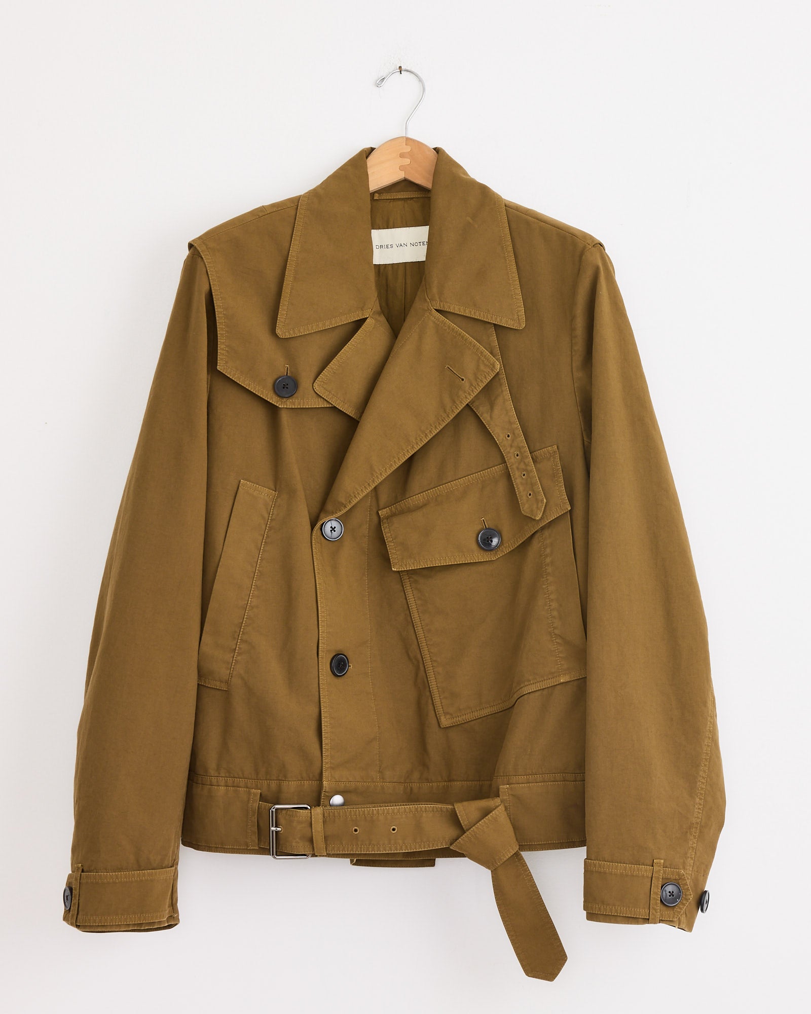 The Dries Van Noten Belted Biker Jacket in Olive features a wide collar, large front pockets, black buttons, and a matching belt. Made in Italy and shown on a wooden hanger against a white background.