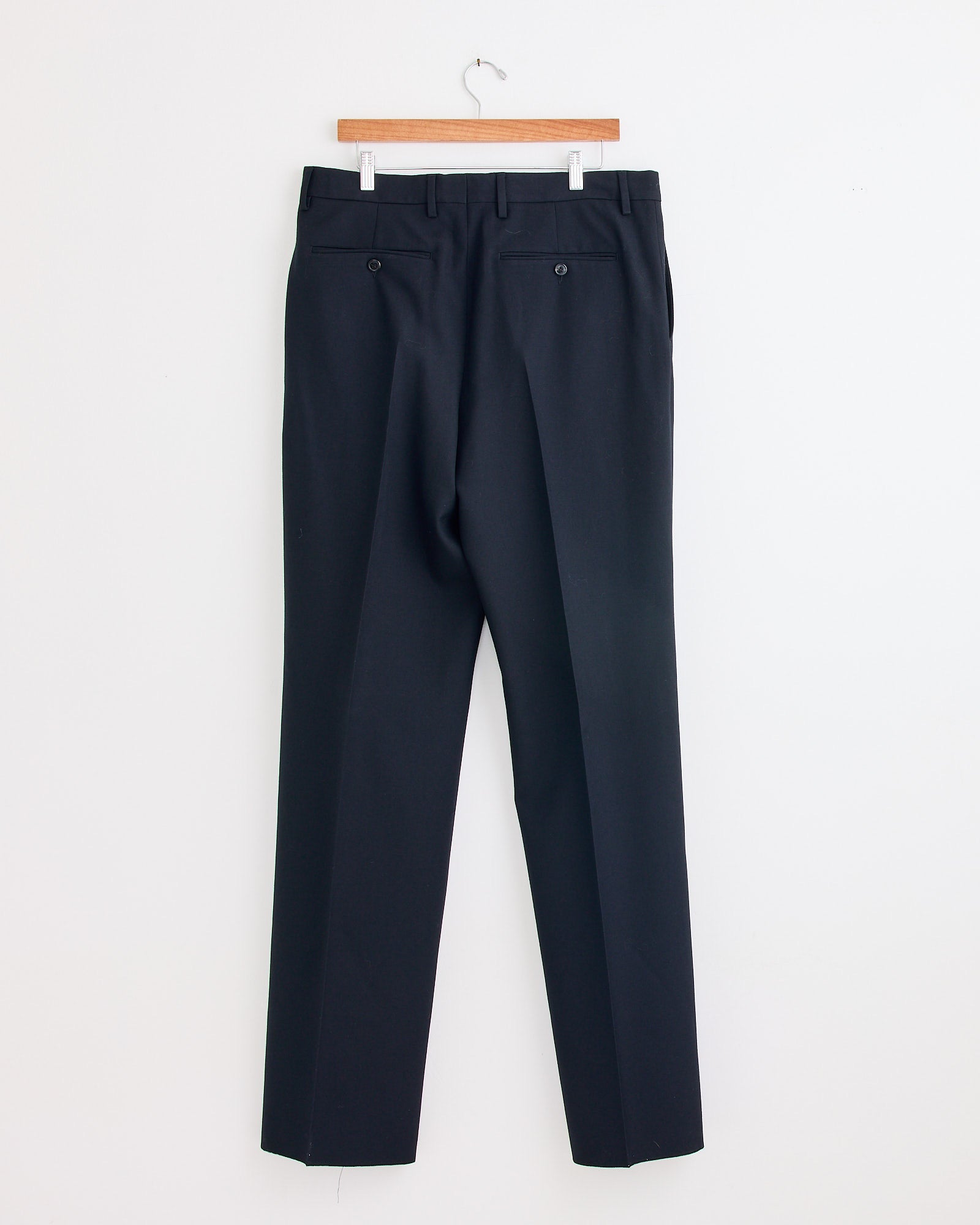 The Kiel 2246 Suit in Black by Dries Van Noten features black wool pants with a modern loose fit, displayed on a wooden hanger and designed for comfort.