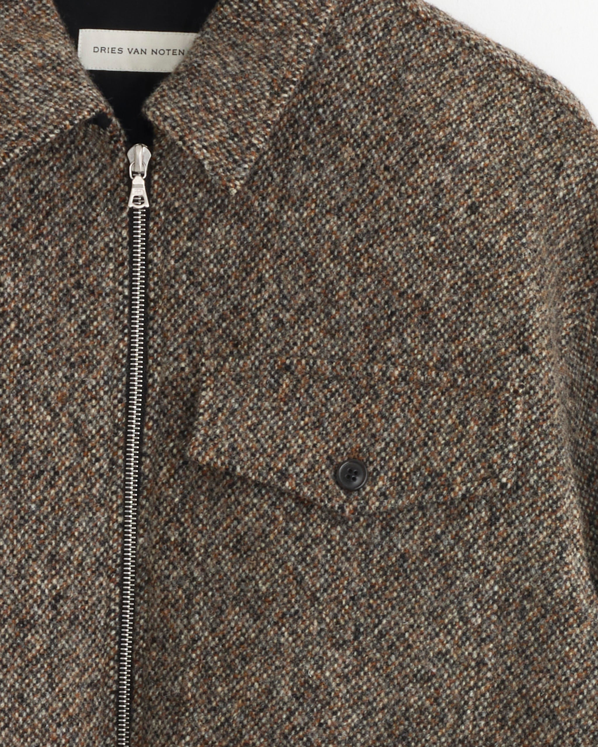 Close-up of Dries Van Noten’s Zip Front Shirt in Rust, designed in textured, thick fabric with an overshirt fit, silver zipper closure, and a buttoned chest pocket.