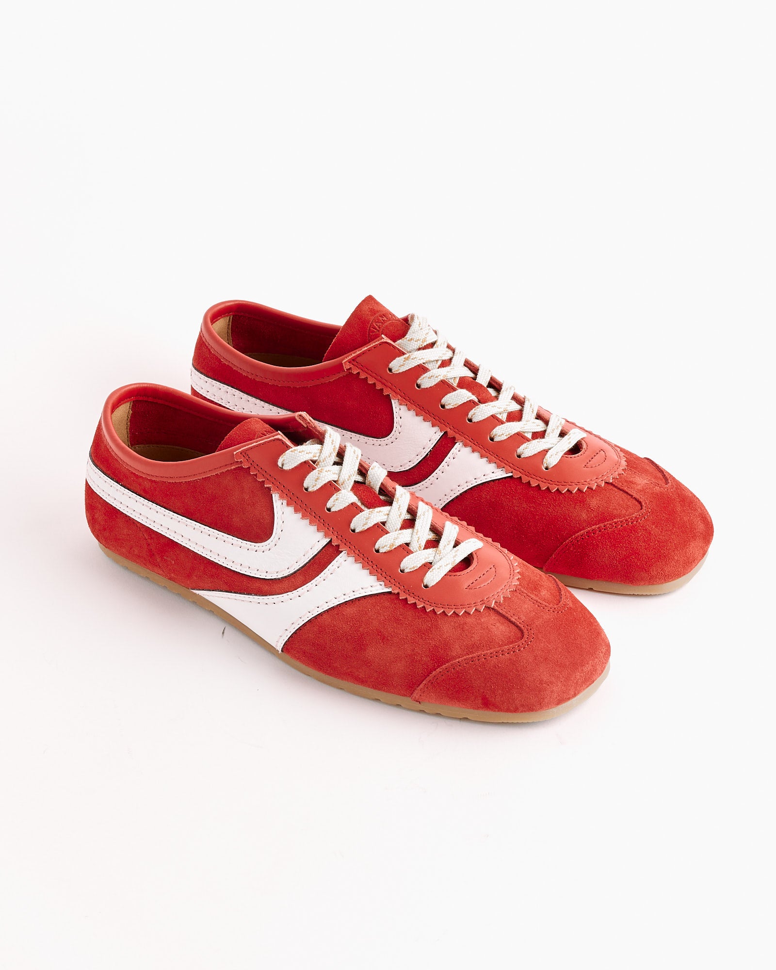 The Dries Van Noten Suede Shoes in Red feature white laces, white side stripes, and gum soles, shown against a plain white background.