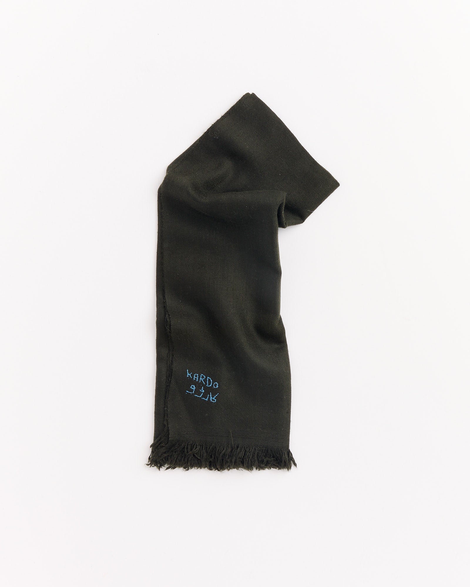 A Handwoven Pashmina Bandana in dark green by Kardo, neatly folded on a white background, features blue embroidery reading KARDO 21/K near the fringed edge.