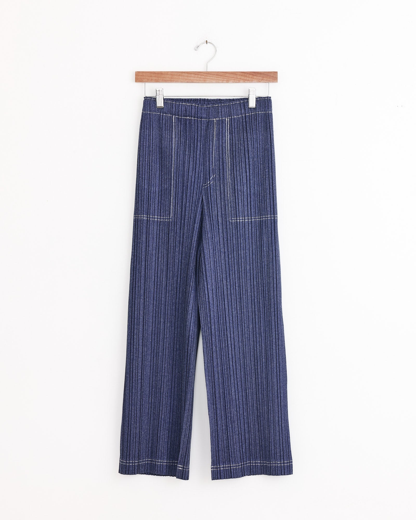 Cotton Denim in Blue by PLEATS PLEASE ISSEY MIYAKE—wide-leg, high-waisted jeans with vertical pinstripes and front patch pockets, shown on a hanger against a white background.