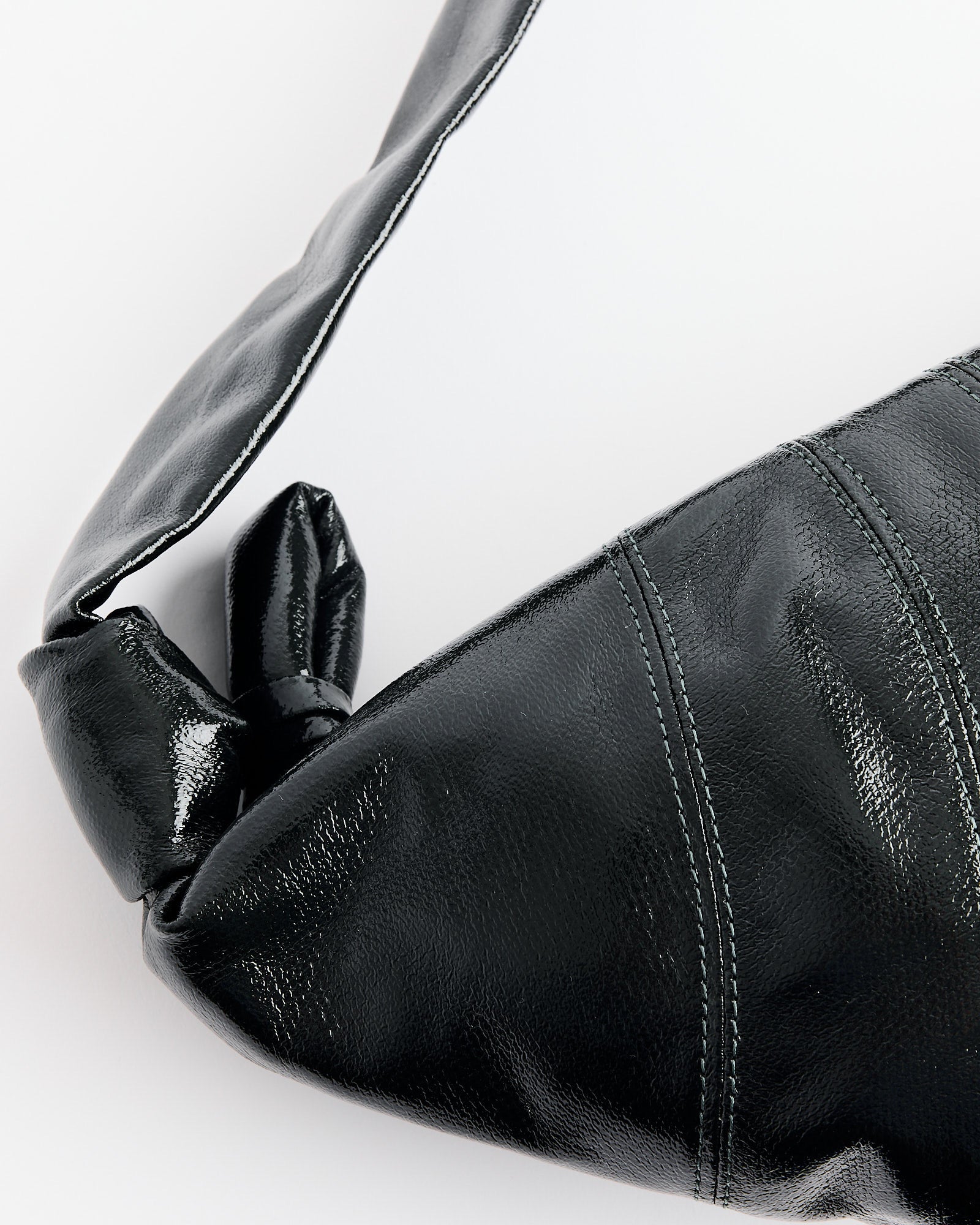 Close-up of the Lemaire Medium Croissant Bag in Forest, crafted in coated cotton canvas with a knotted strap and visible stitching, shown against a plain white background.