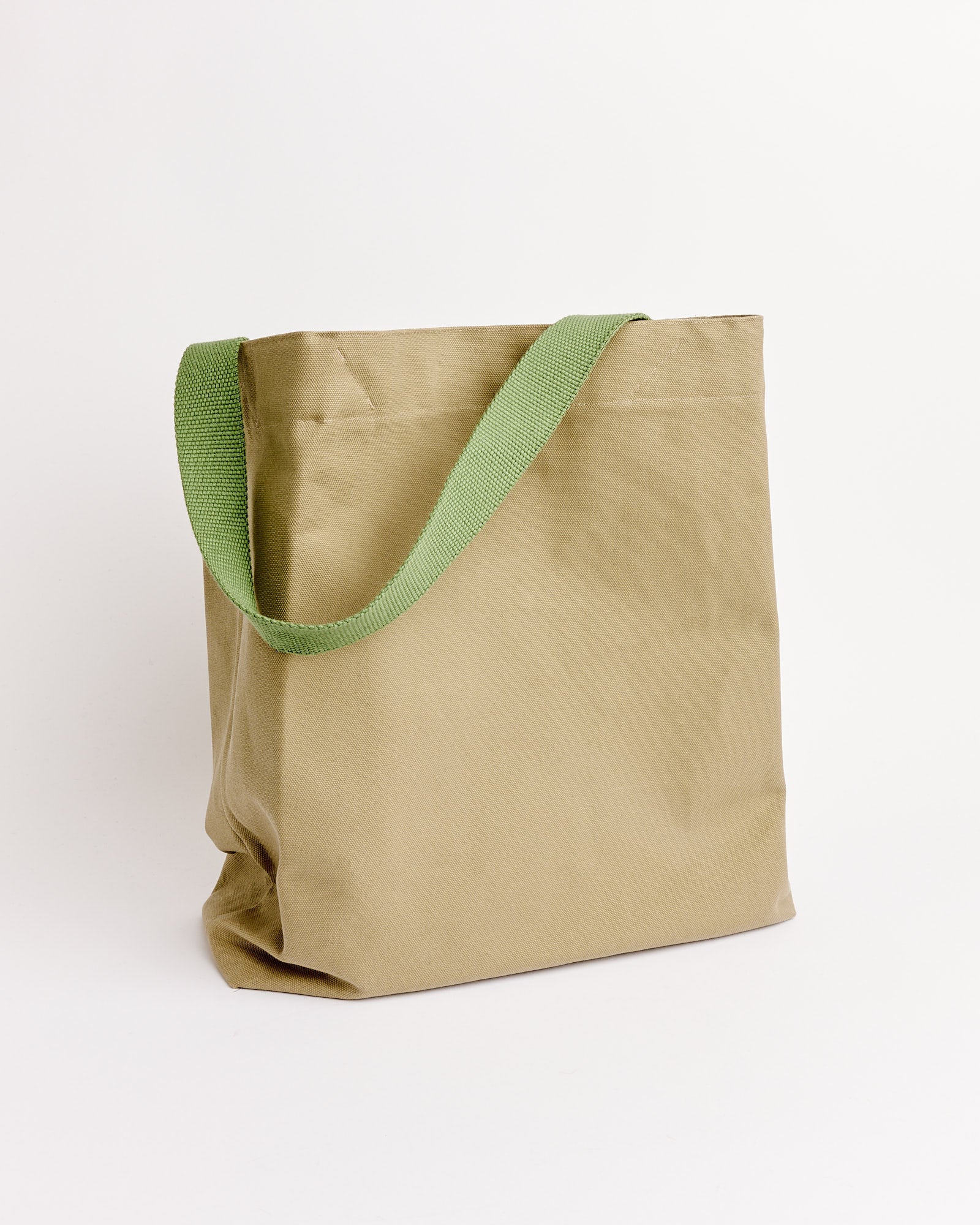 The Our Legacy Towering Tote in Cliff Grey stands upright against a white background, featuring a wide green shoulder strap.