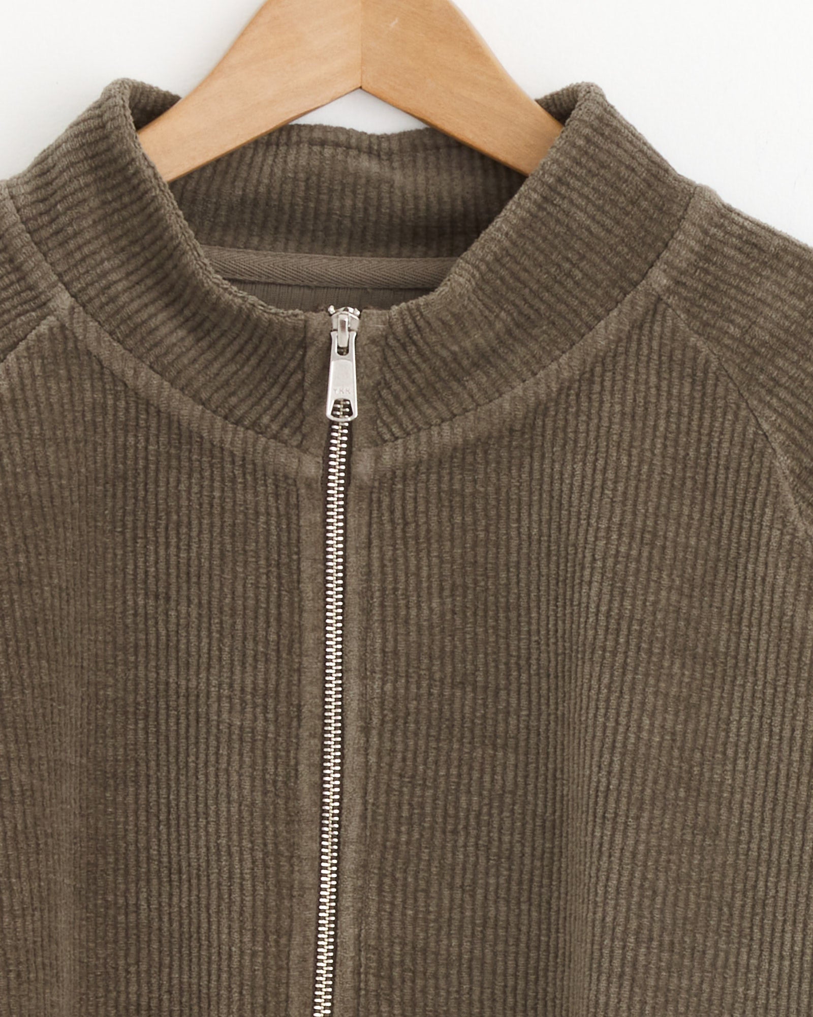 A close-up of the mfpen Leisure Zip Up in Faded Taupe, a relaxed fit corduroy jacket with a ribbed texture and silver front zipper—perfect for casual style.