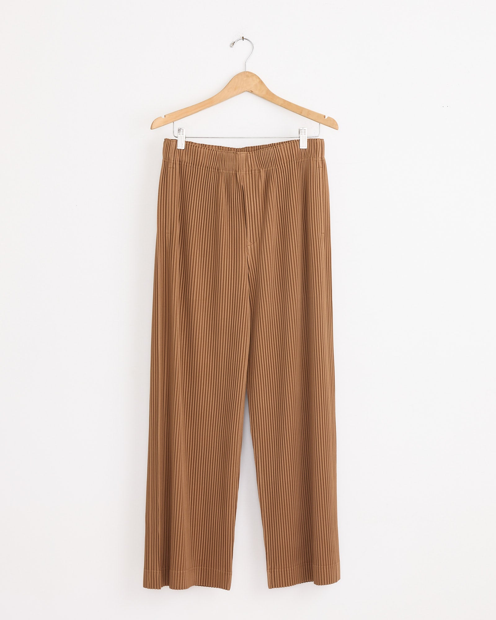 MC Oct Pant in Paesina Brown by Homme Plissé Issey Miyake displayed on a swinger.