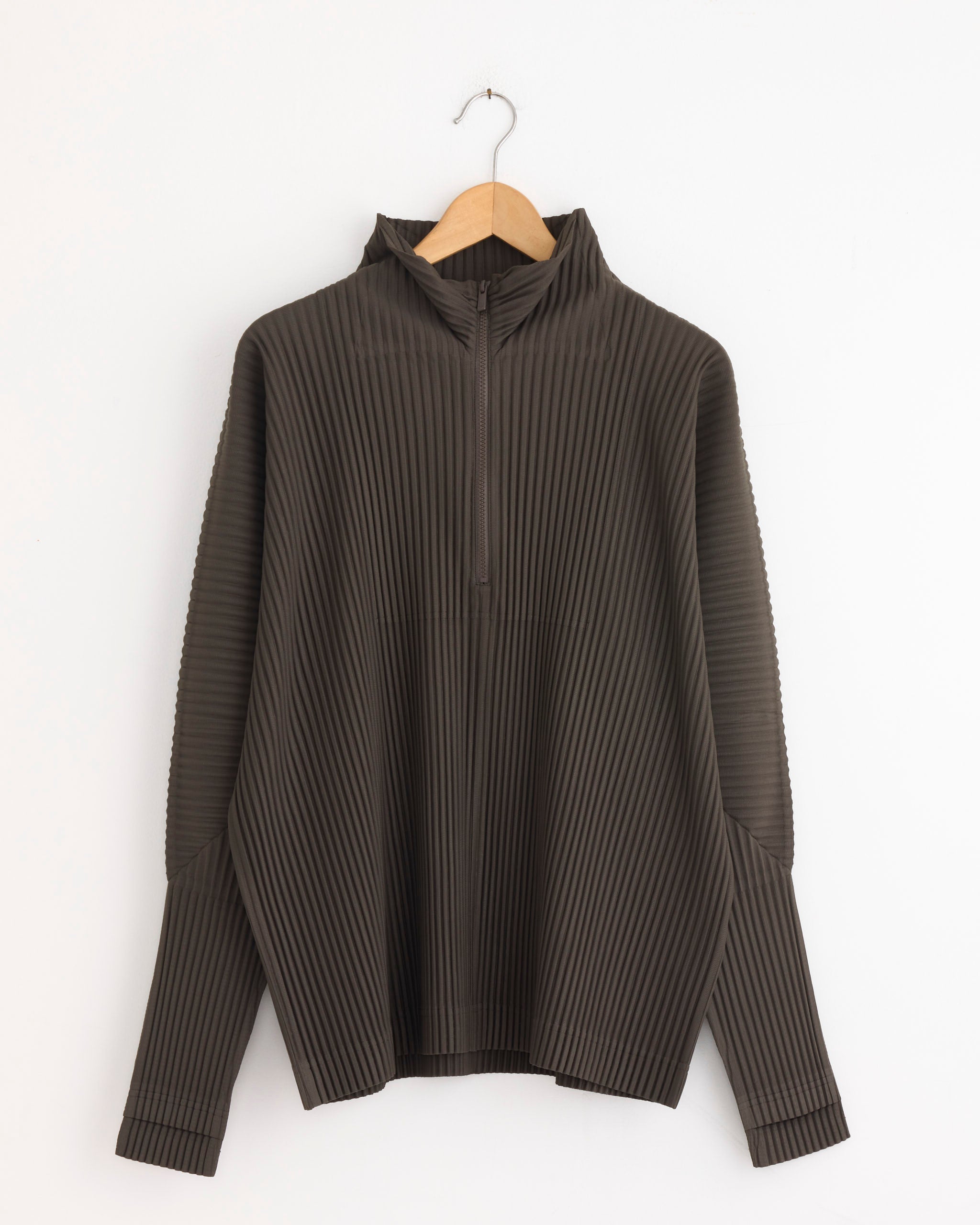 The MC Nov Jacket in Mudstone Grey by Homme Plissé Issey Miyake hangs on a wooden hanger against a white background. For fit or sizing questions, please contact our online chat support.