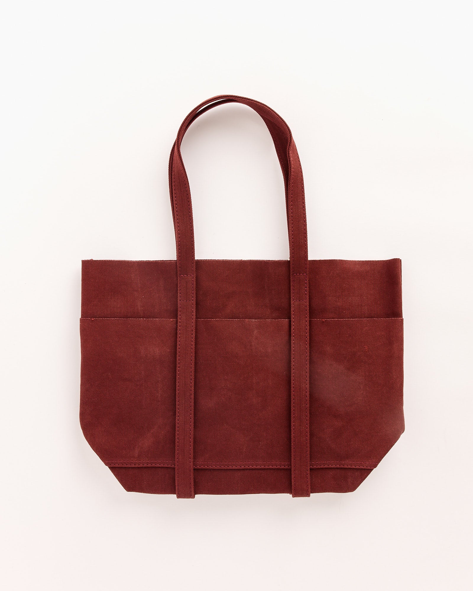 The Amiacalva Washed Canvas 6 Pockets Small Tote in Burgundy features a classic silhouette with two long handles and visible stitching, inspired by the original 6 pockets tote, shown against a plain white background.
