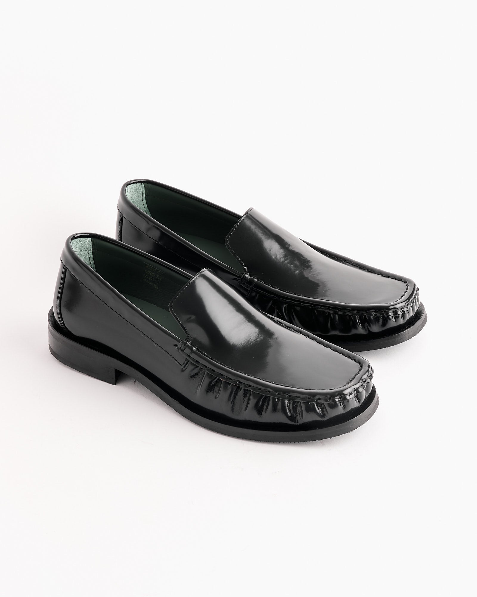 The Michel Loafer in Black by Vinny's features shiny Polido leather, a square toe, low heels, and subtle wrinkling around the toe area, shown on a white background.