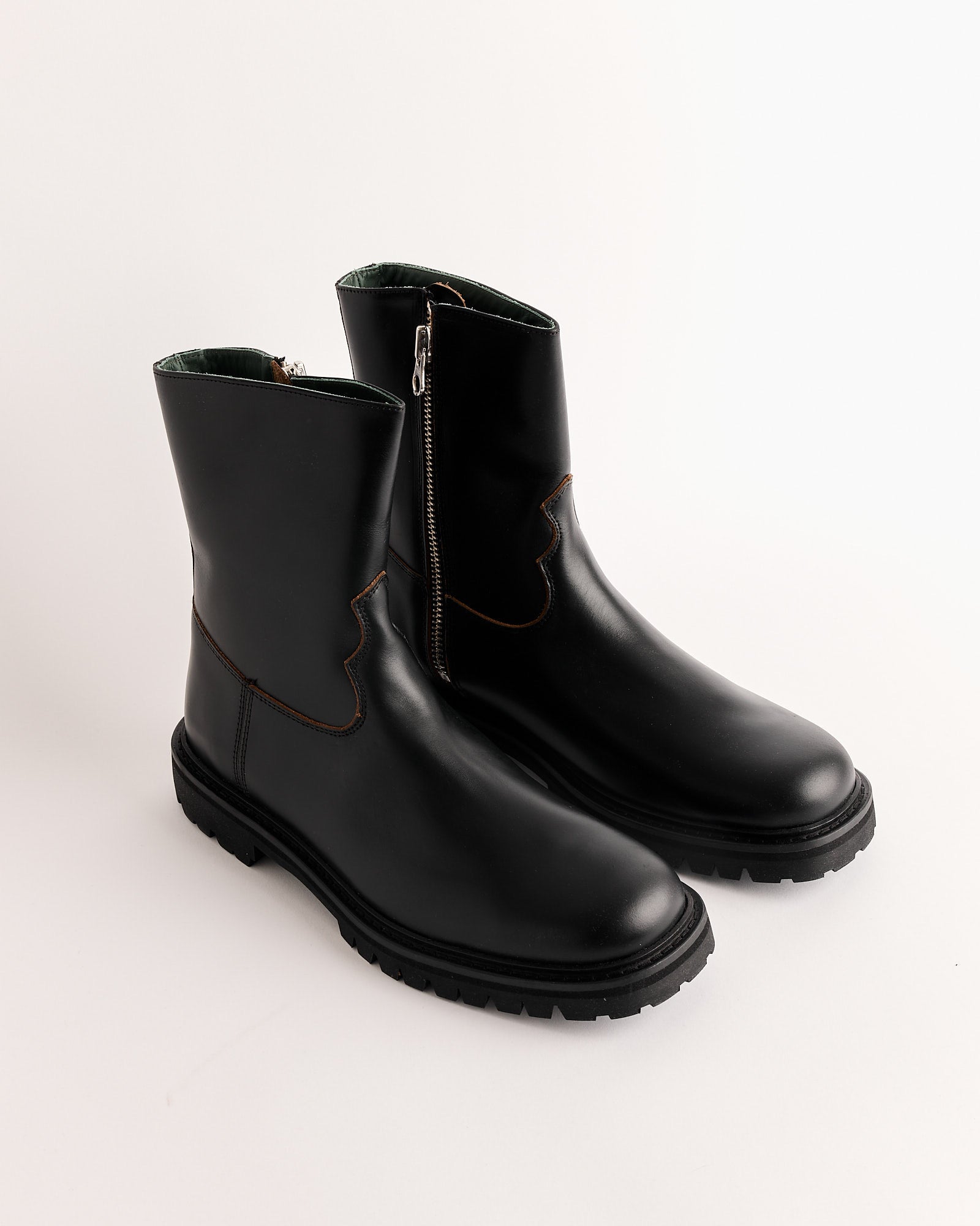 The Moto Boot in Black by Vinny's features black nappa leather, side zippers, chunky Vibram soles, and brown stitching, shown on a plain white background.