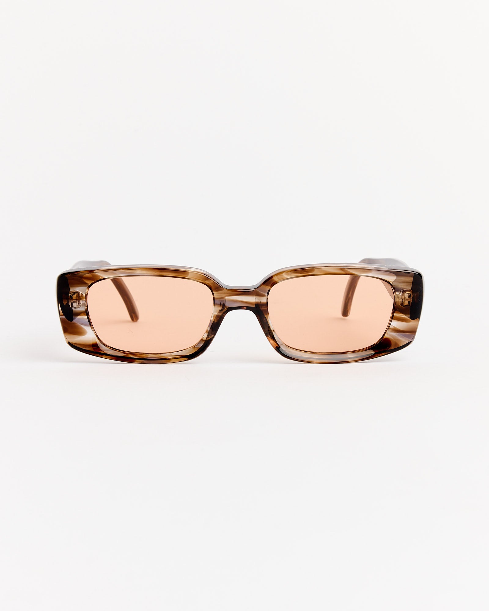 Our Legacy Samhain Sunglasses in Sewer Surfer feature rectangular, thick brown frames with a tortoiseshell style and light pink-tinted lenses, shown against a plain white background.