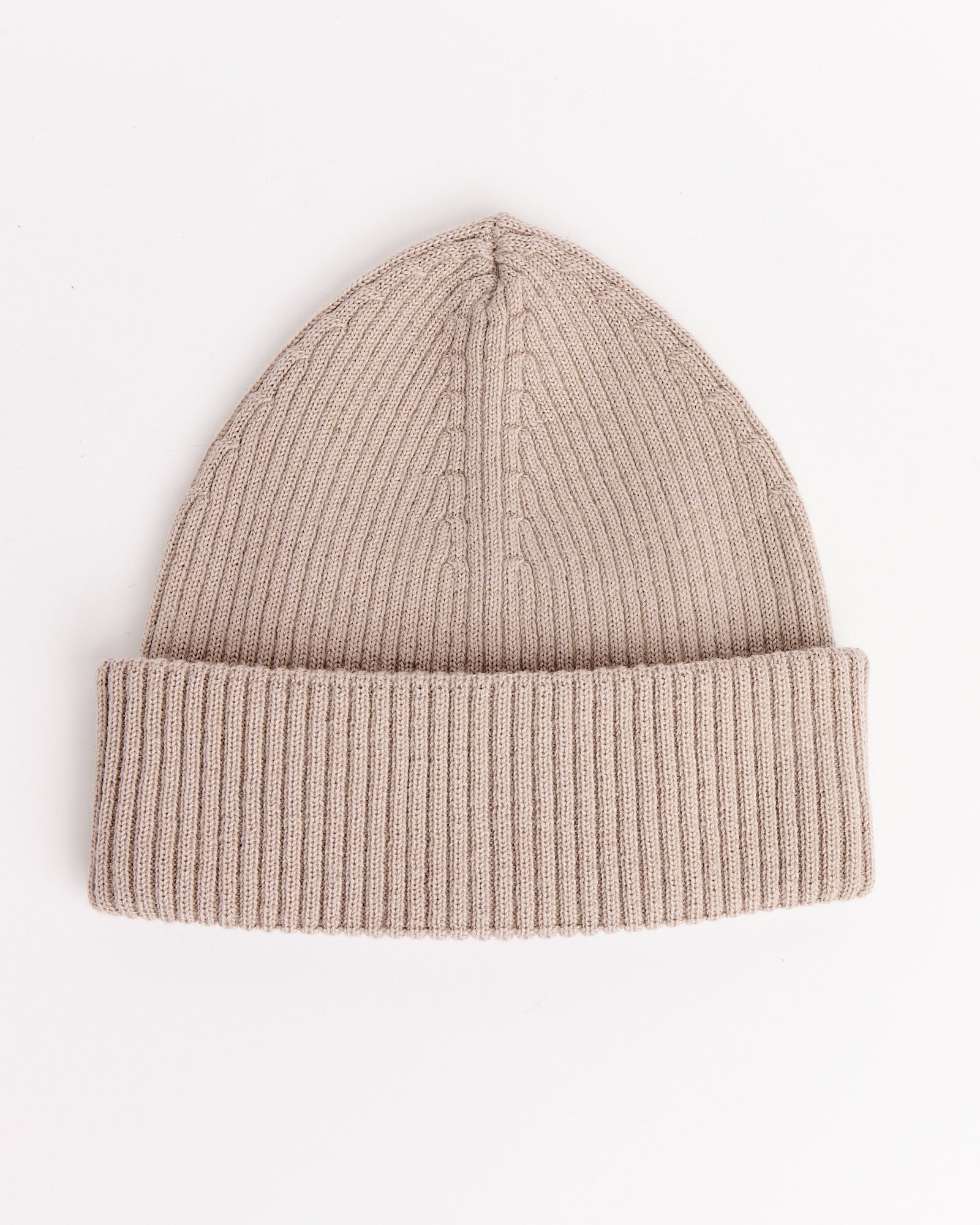 The Our Legacy Knit Hat in White Sand is a beige, ribbed knit beanie with a folded cuff, shown flat on a white background.