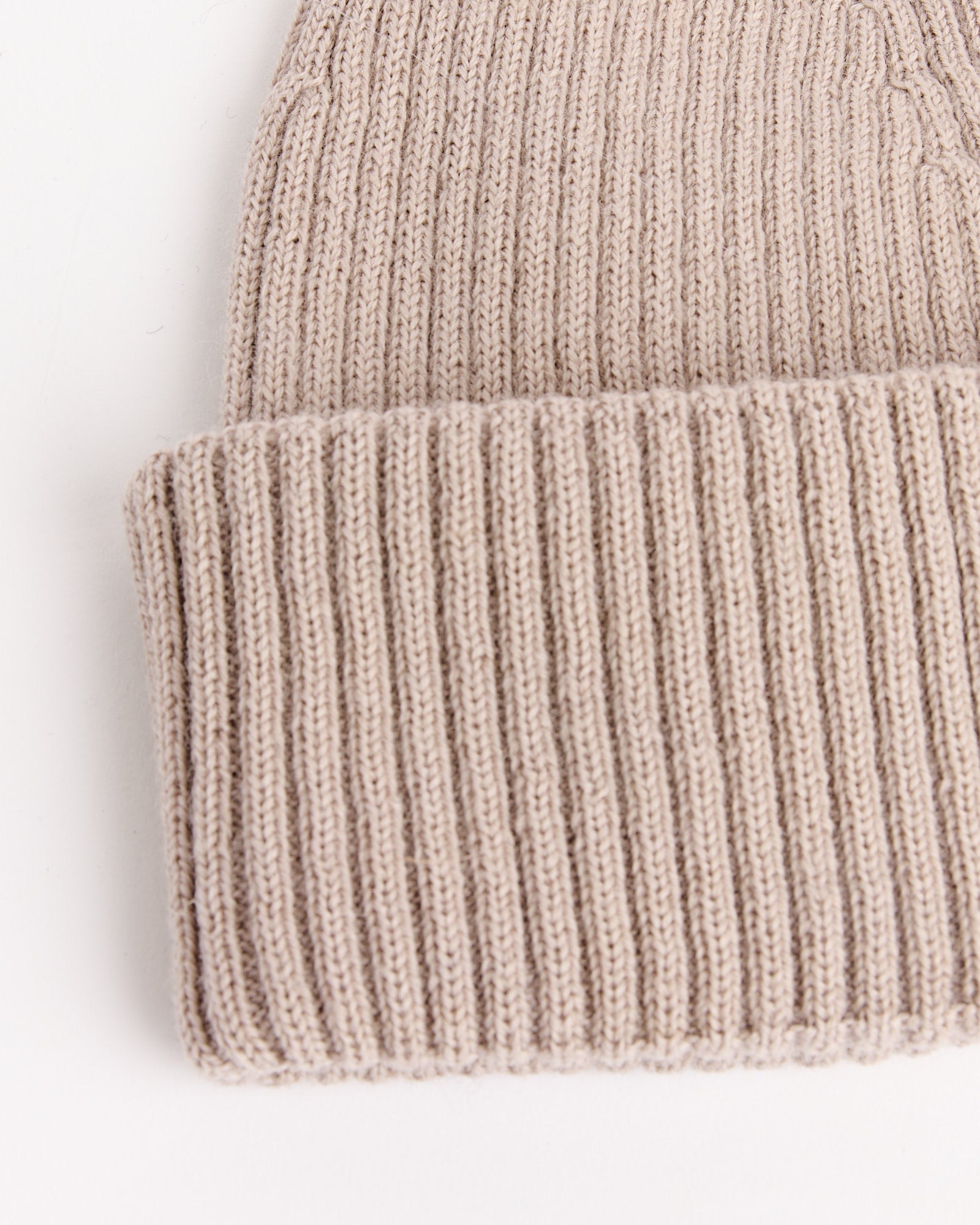 A close-up of the Our Legacy Knit Hat in White Sand, featuring a folded brim, displayed against a white background.