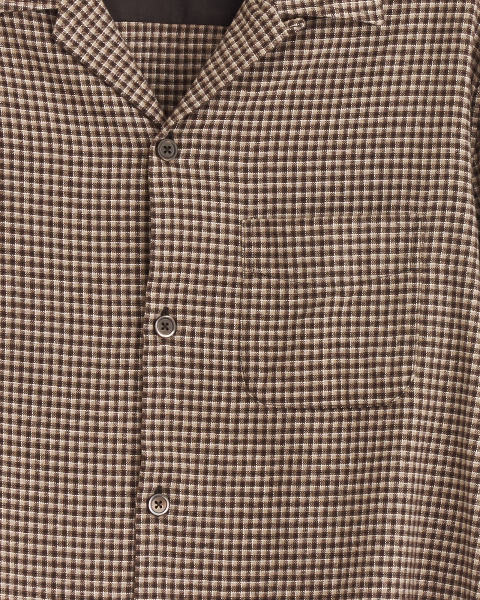Close-up of the Our Legacy Heusen Shirt in Endino Flannel Check, showcasing a boxy fit, chest pocket, and three visible buttons. The soft brown and cream check fabric adds a textured look.
