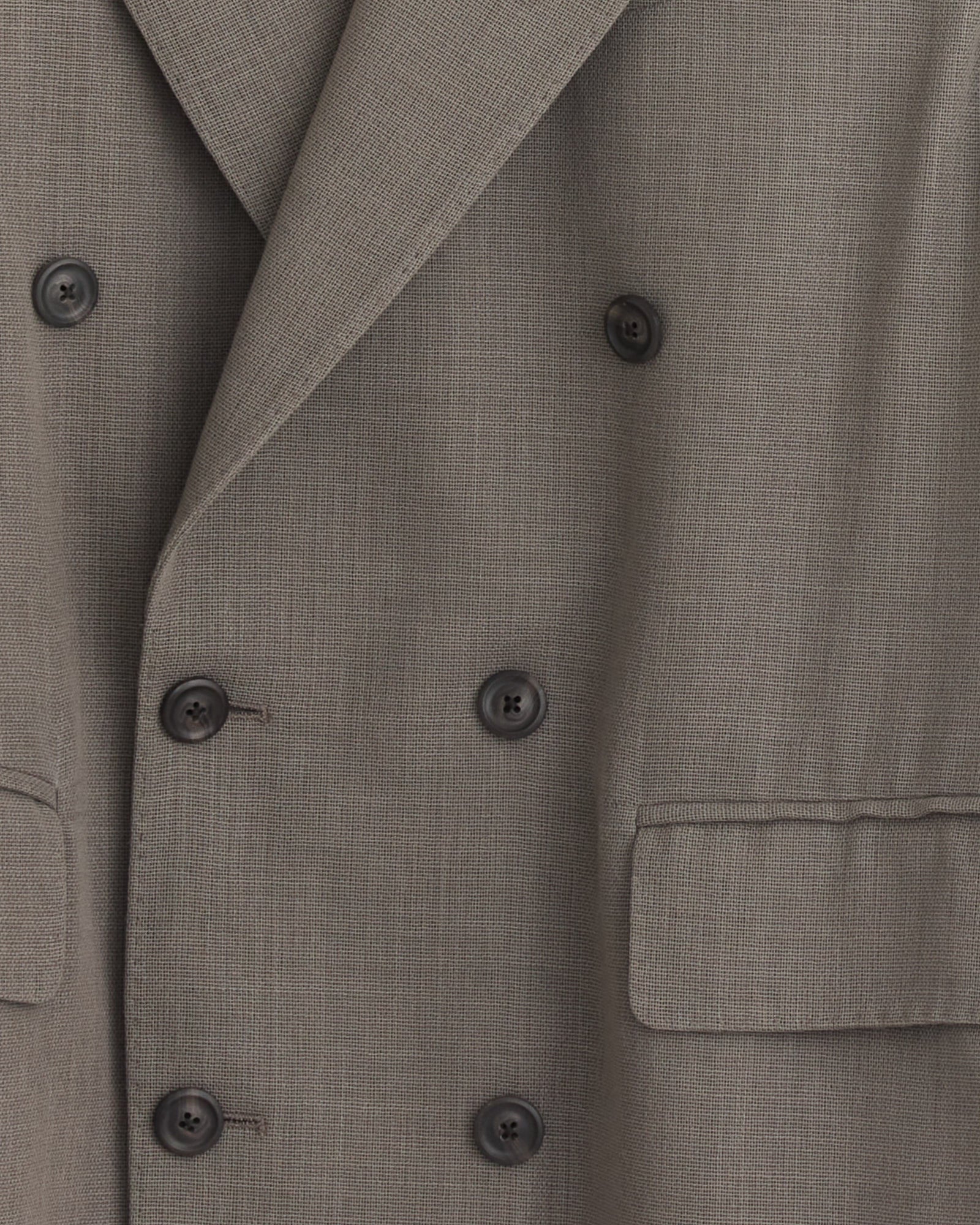 Close-up of the Sharp DB Blazer in Double Grey by Our Legacy, featuring six black buttons, two front flap pockets, textured fabric, and wide notched lapels for a refined, sophisticated look.