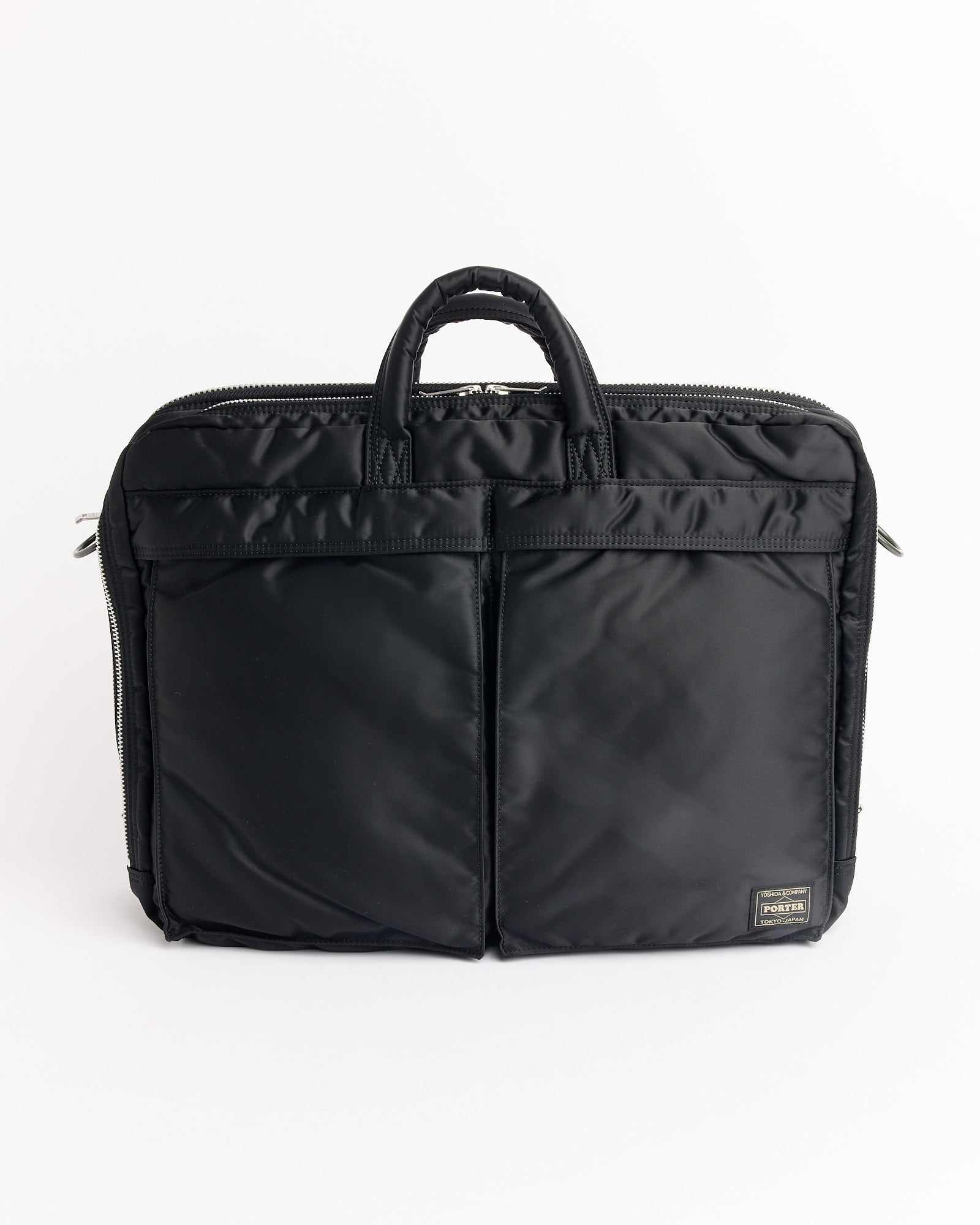 The Porter Tanker 2Way Document Zip Bag in Black features two front pockets, double handles, and a small rectangular logo patch at the bottom right, shown against a plain white background.