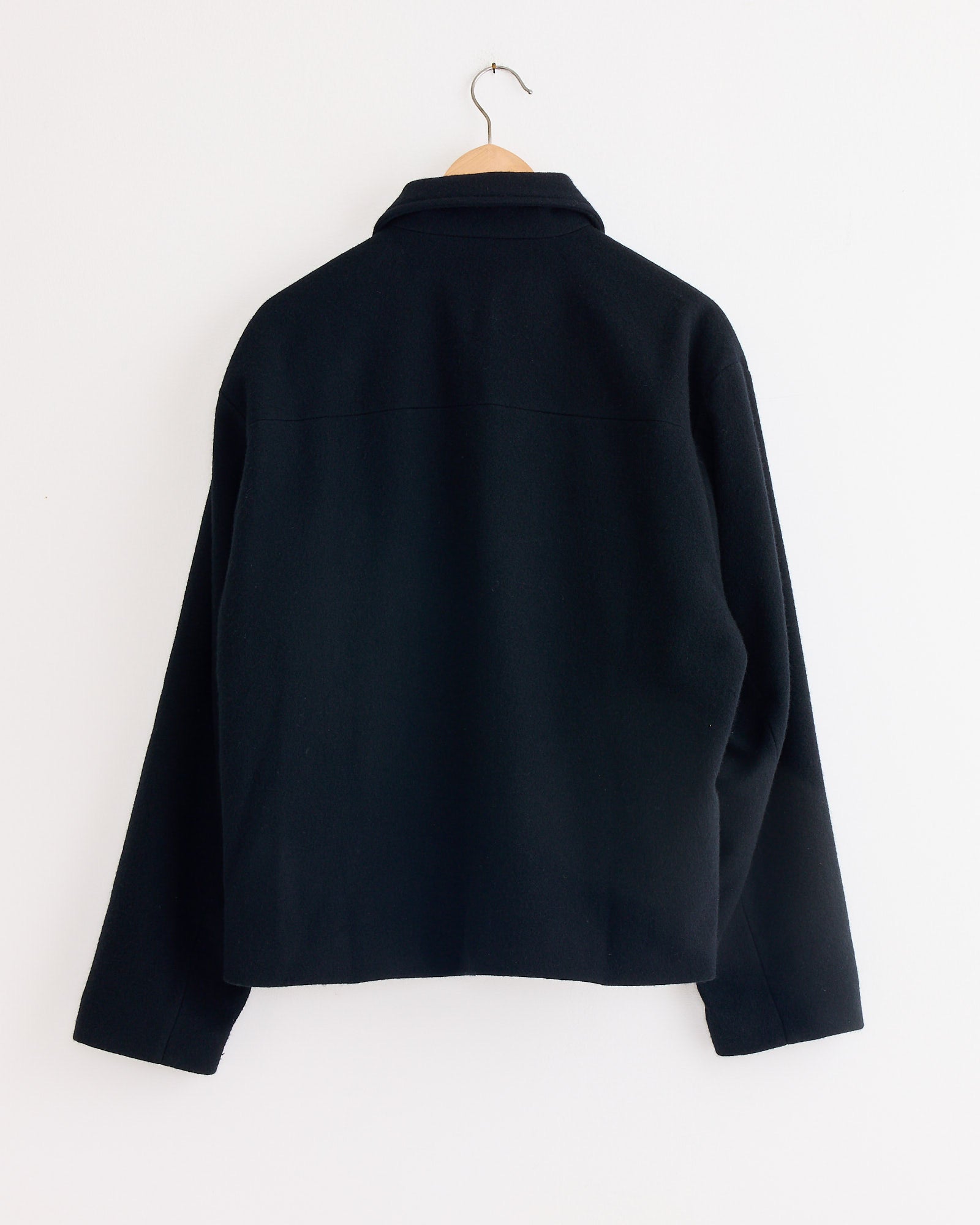 The Arpenteur Lux J Lined Jacket in Black, a French-made cotton oxford workwear piece, is displayed on a swinger.