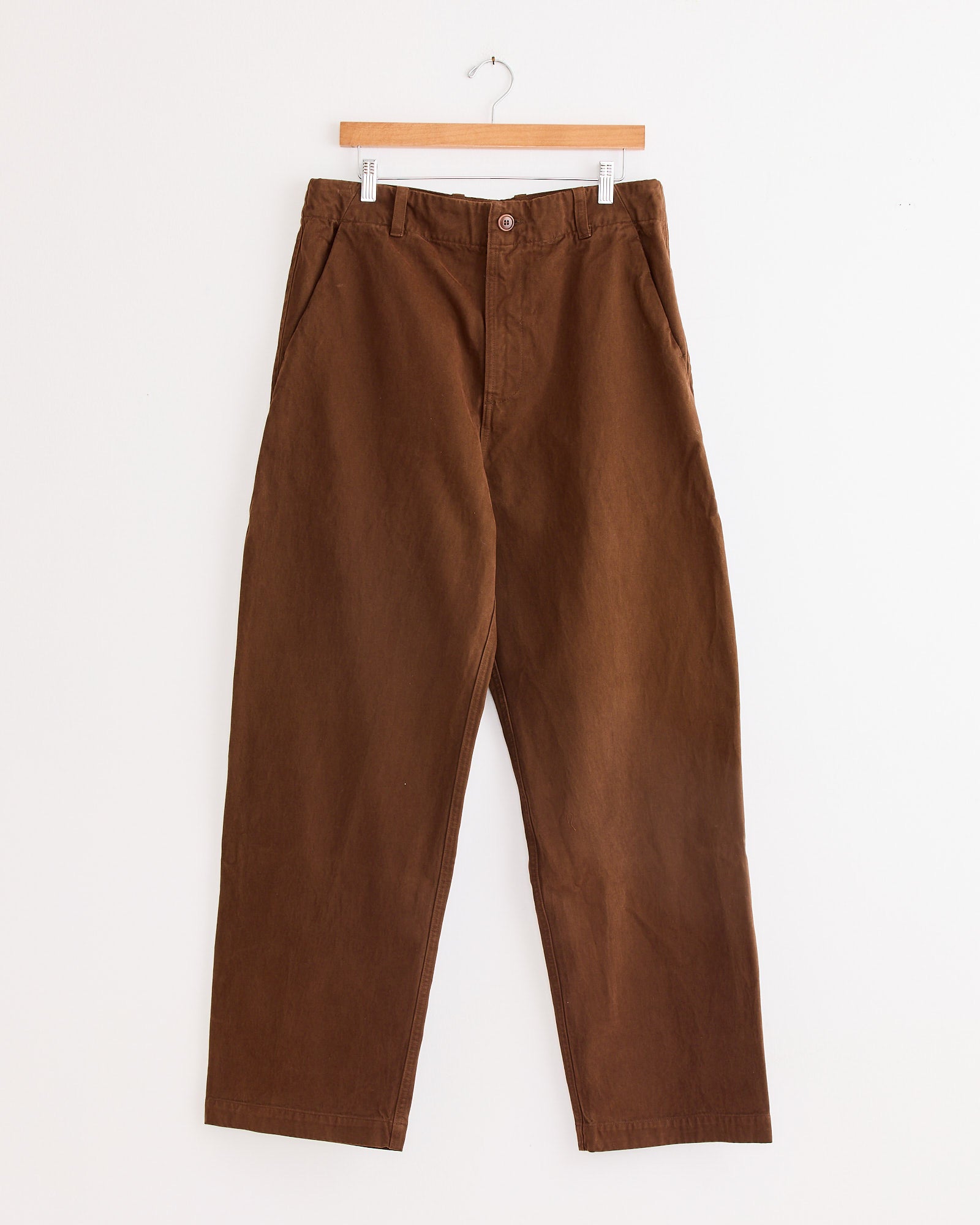 The Lux P Trouser in Tobacco by Arpenteur, displayed on a hanger, is crafted from durable slub oxford cotton.