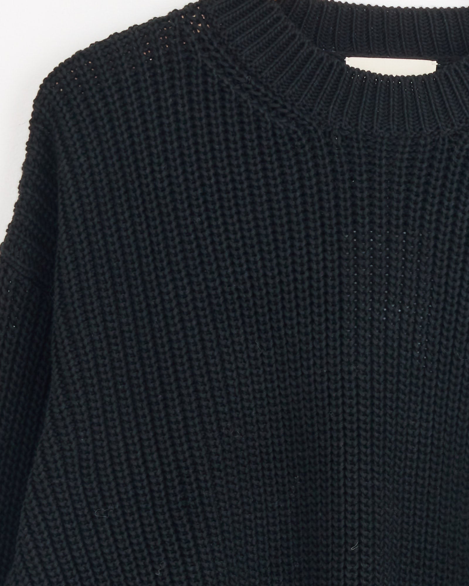 Close-up of the Shaina Mote Perle Sweater in Onyx—a black, cropped crewneck with a thick textured knit and ribbed neckline—shown against a white background.