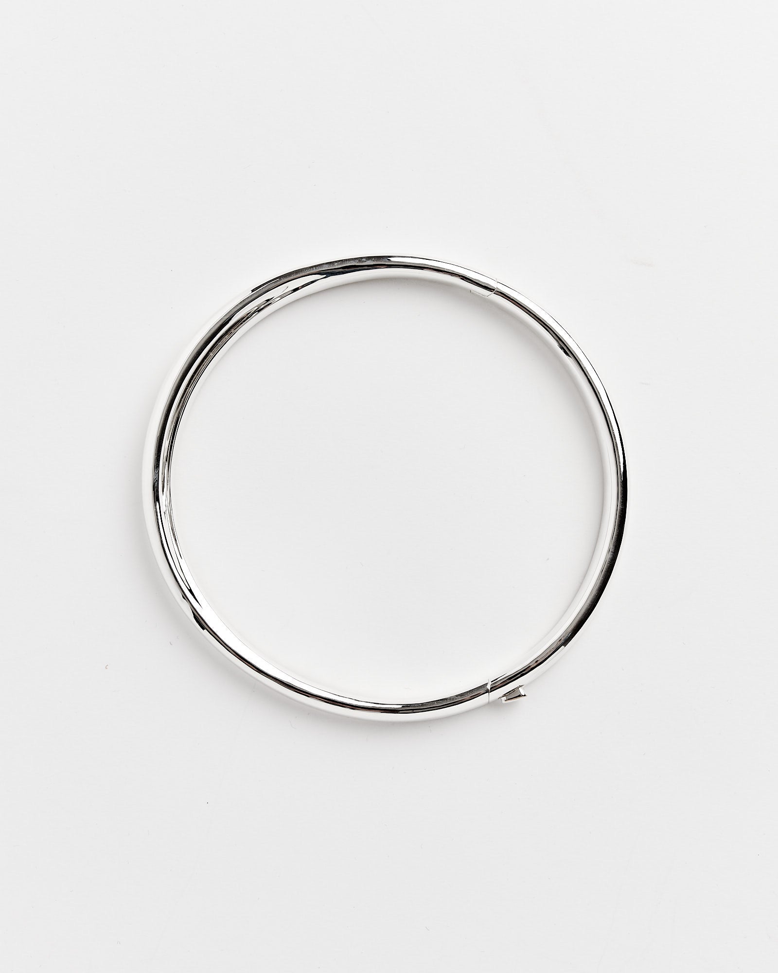 A sleek Recycled Brass Neck Collar by Completedworks is shown on a plain white background, perfect for any outfit. For sizing assistance, our online chat is here to help.