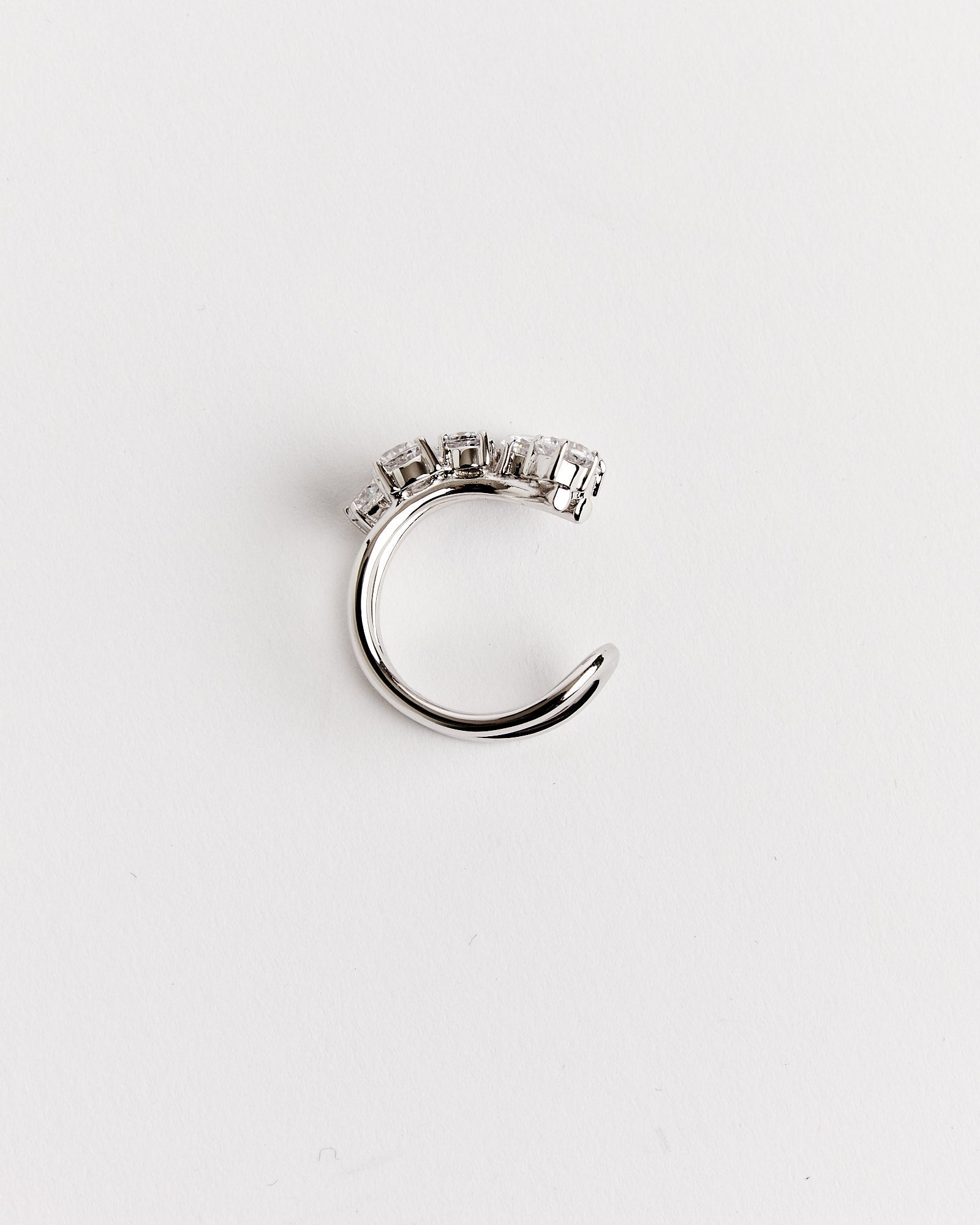 The Recycled Silver Myth CZ Ring by Completedworks features five square-cut clear gemstones set along the top. Displayed on a plain white background. For sizing questions, our online chat is available to assist you.