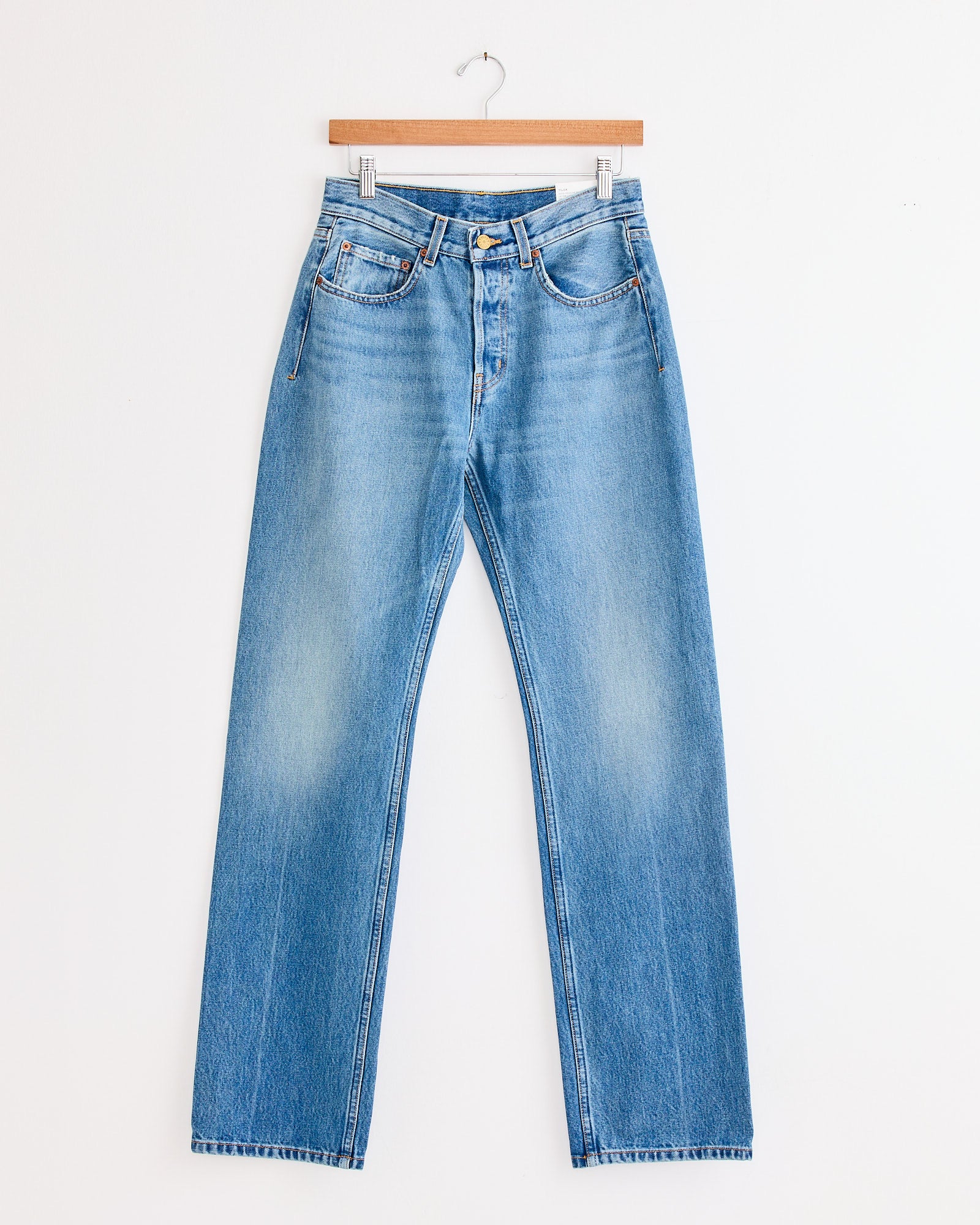 A pair of B Sides Tilda Jean in Jane Wash mid rise straight jeans swings gently, crafted from classic indigo denim.