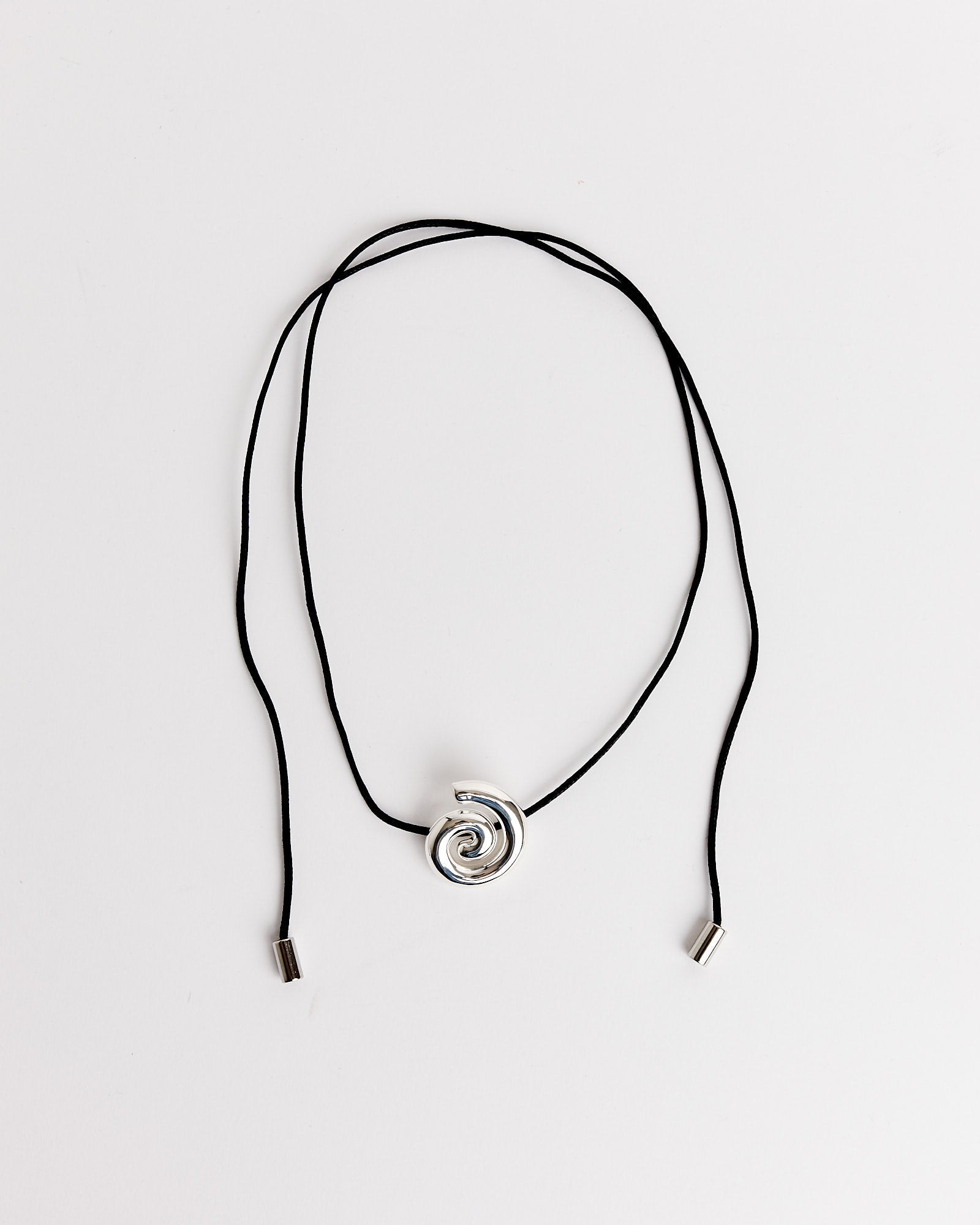 The NOMIA Spiral Cord Necklace features a black cord with metal tips and a silver spiral pendant, displayed on a white background. For sizing questions, use our online chat for assistance.
