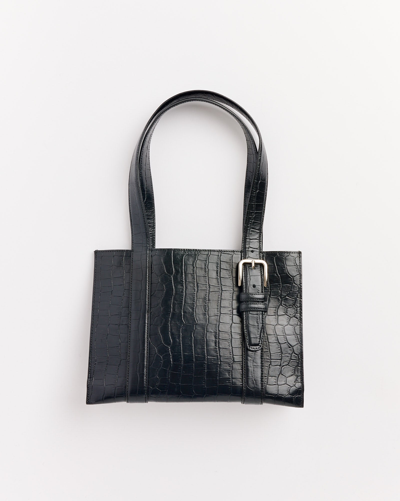 The Cordera Buckle Crocodile Bag in Black features a glossy crocodile pattern, long handles, and a silver buckle. Displayed on a white background. Chat with us online for any sizing or fit questions.