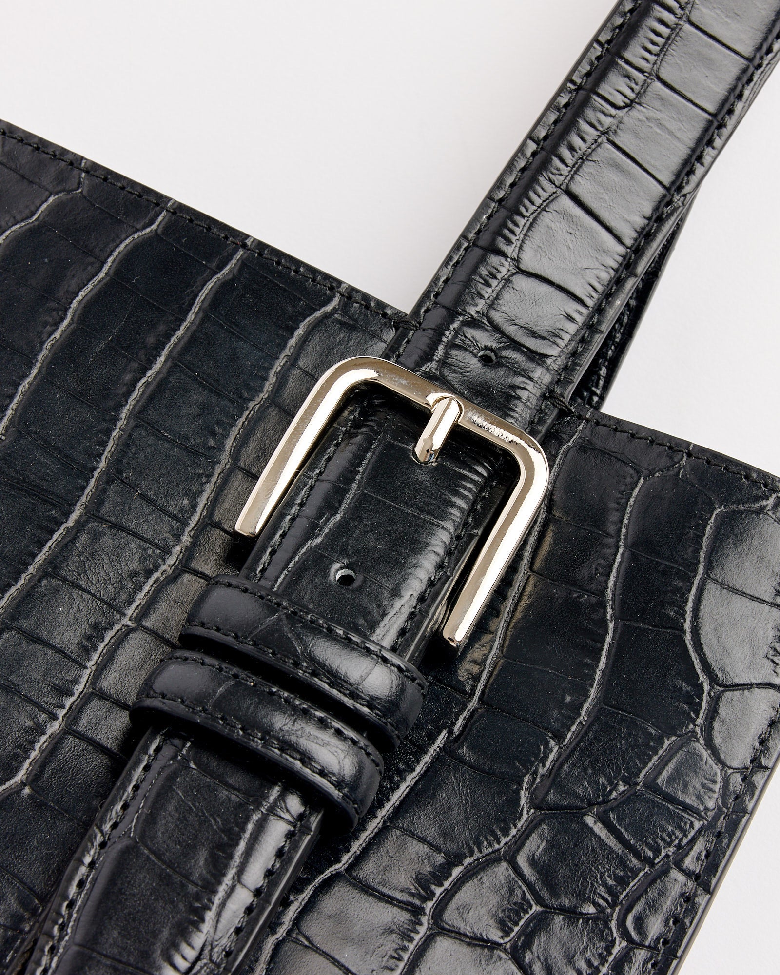Close-up of the Cordera Buckle Crocodile Bag in Black, featuring textured faux-crocodile leather, a shiny silver buckle, and fine stitching—contact us via online chat for fit or sizing questions.
