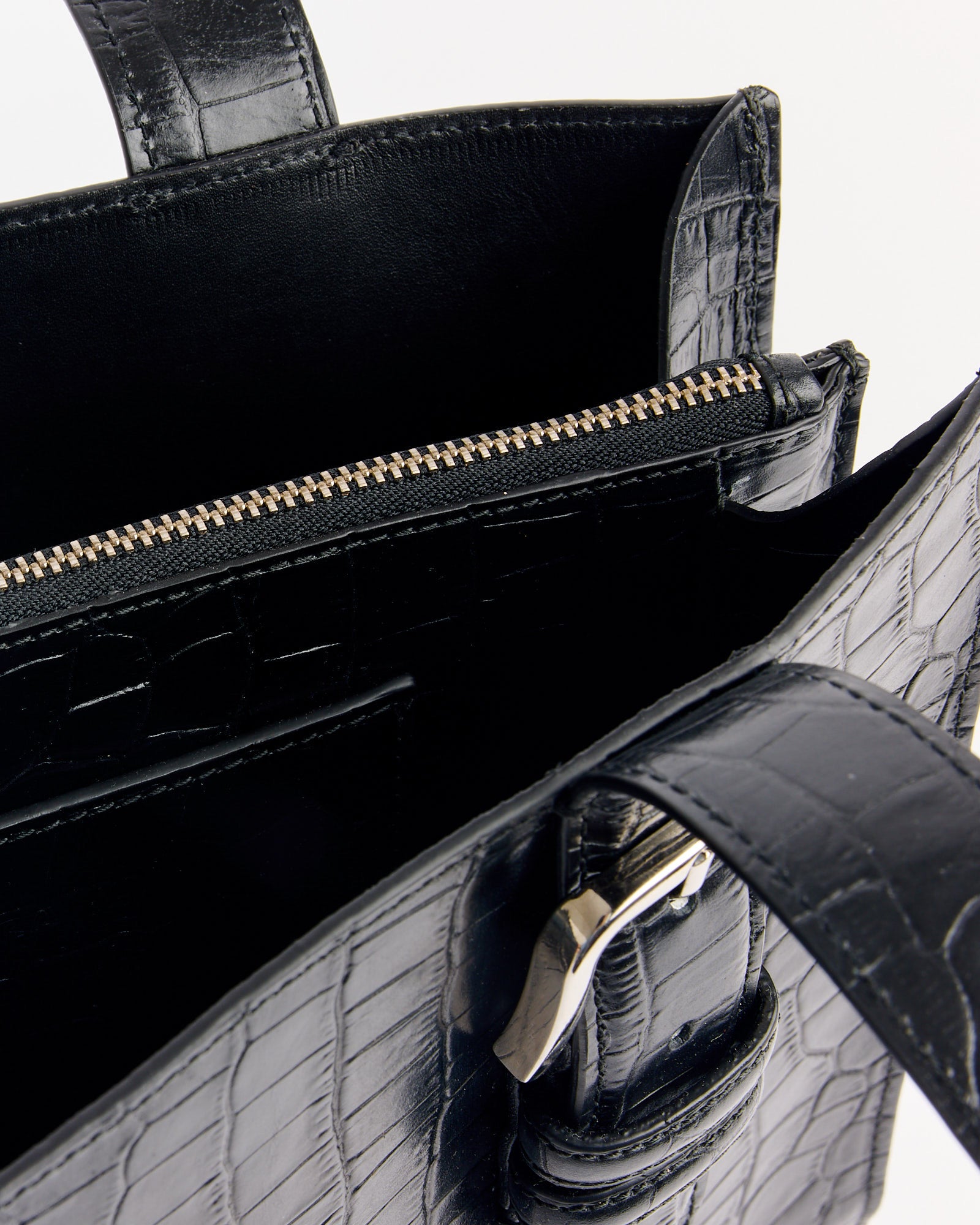 Close-up of the Buckle Crocodile Bag in Black by CORDERA, featuring textured leather, crocodile pattern, silver zipper pocket, and metal buckle handle. For sizing or fit questions, contact us via online chat.