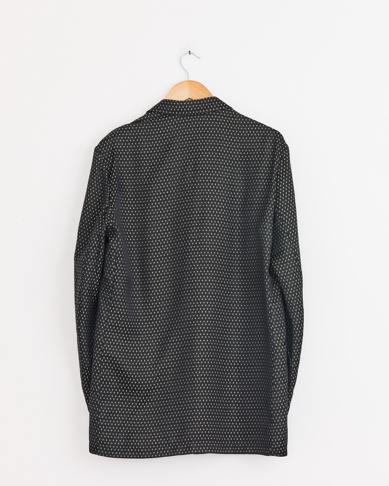 A black Jacquard Double-Breasted Blazer by Dries Van Noten hangs on a wooden hanger against a plain white wall, displayed with the back facing forward.