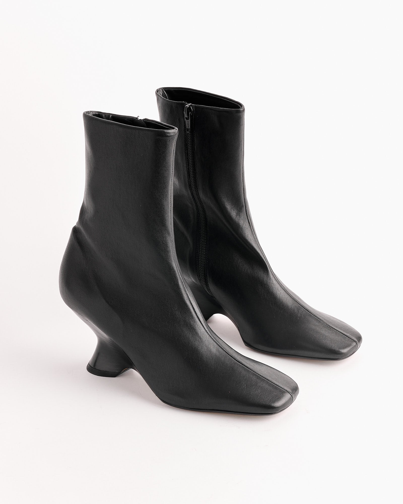 The Dries Van Noten Leather Wedge Boot in Black features sculptural heels and square toes, shown against a white background.