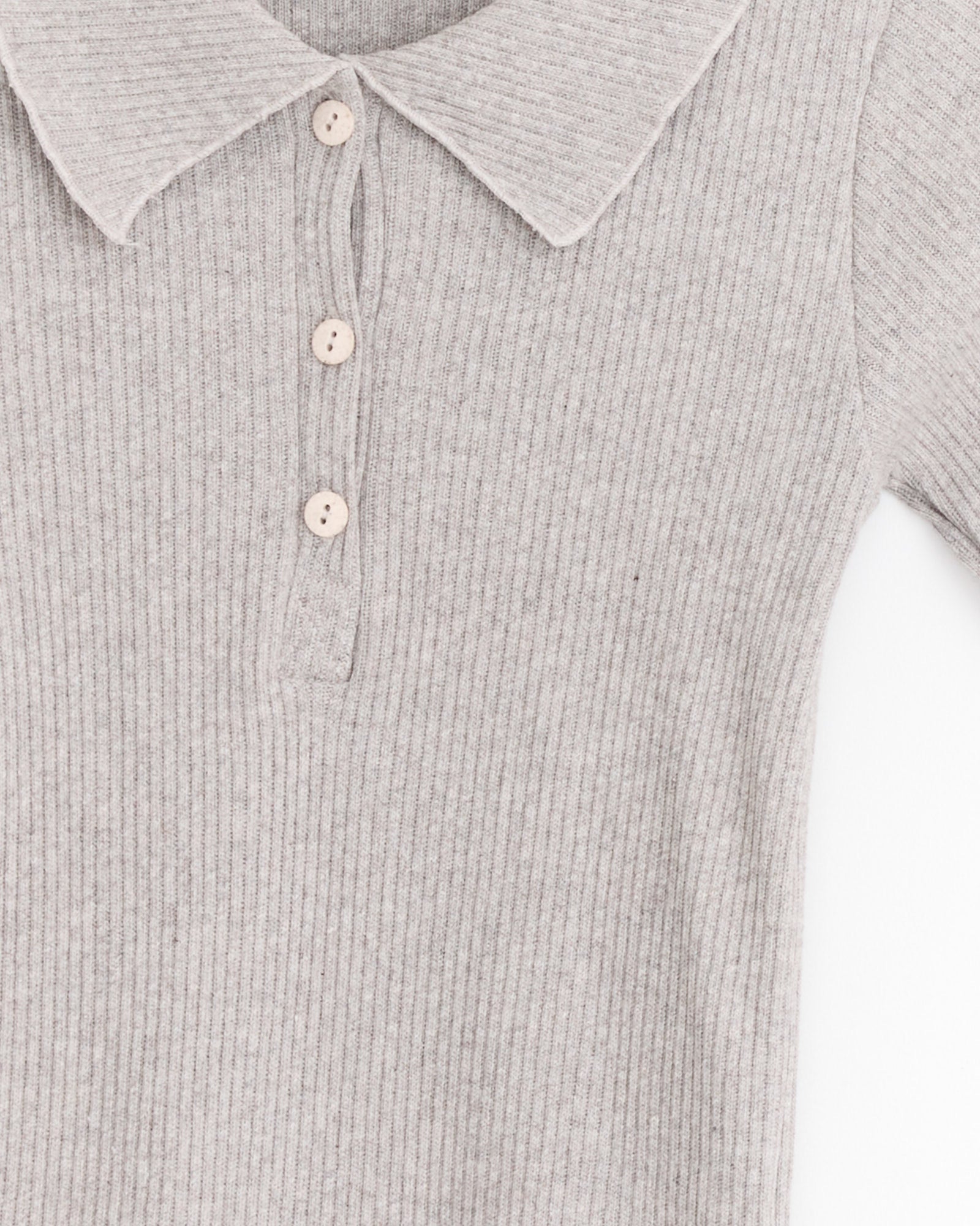 Close-up of the Baserange Dual Polo in Grey Melange, a light grey ribbed knit long-sleeve shirt with a collar and three beige buttons, made from organic cotton and shown from the upper portion against a white background.