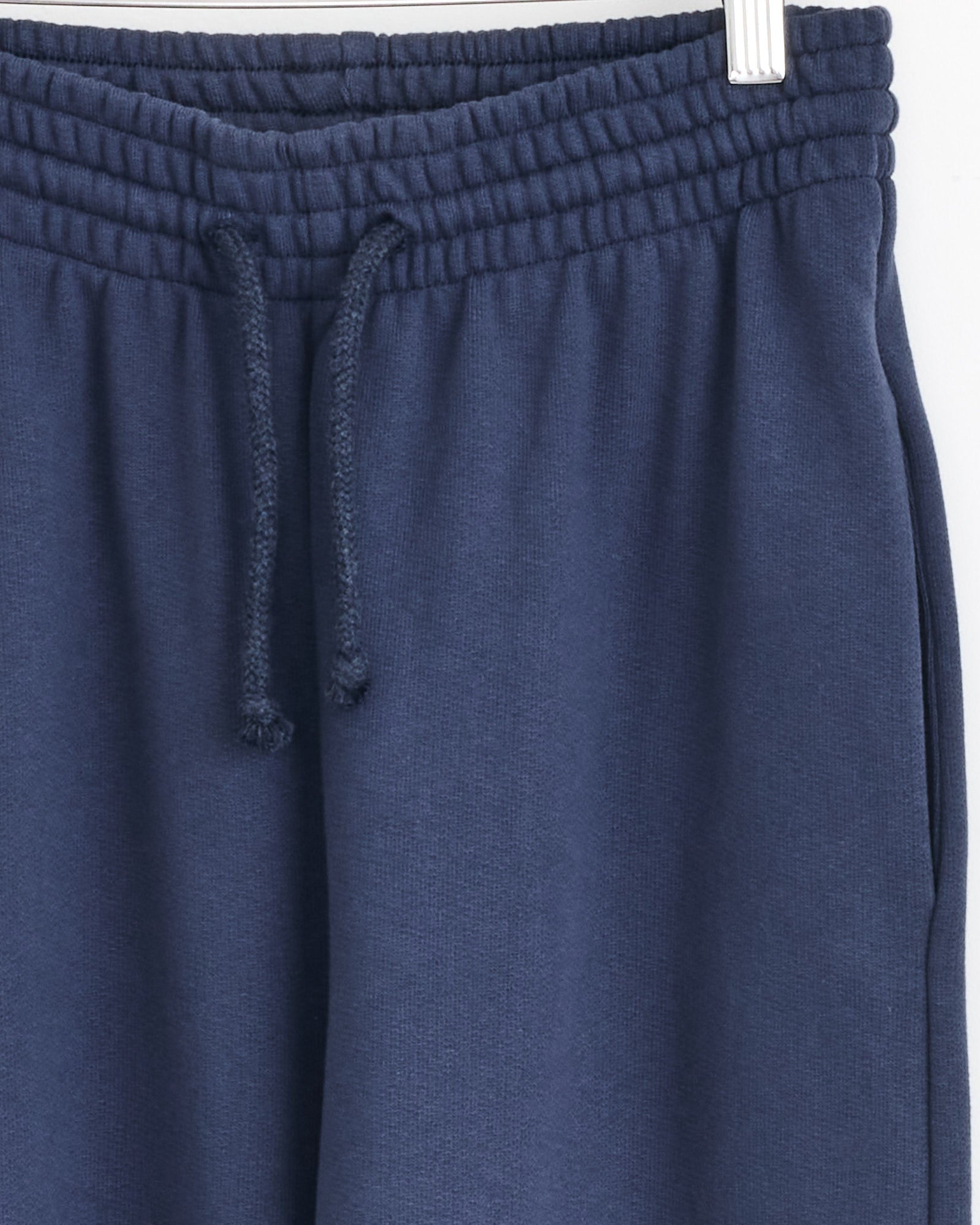Close-up of the waistband of Baserange’s Sweatpant in Echo Blue, showing an elastic band and center-tied drawstring. Made from recycled cotton, the soft fabric offers comfort—perfect for sustainable loungewear.