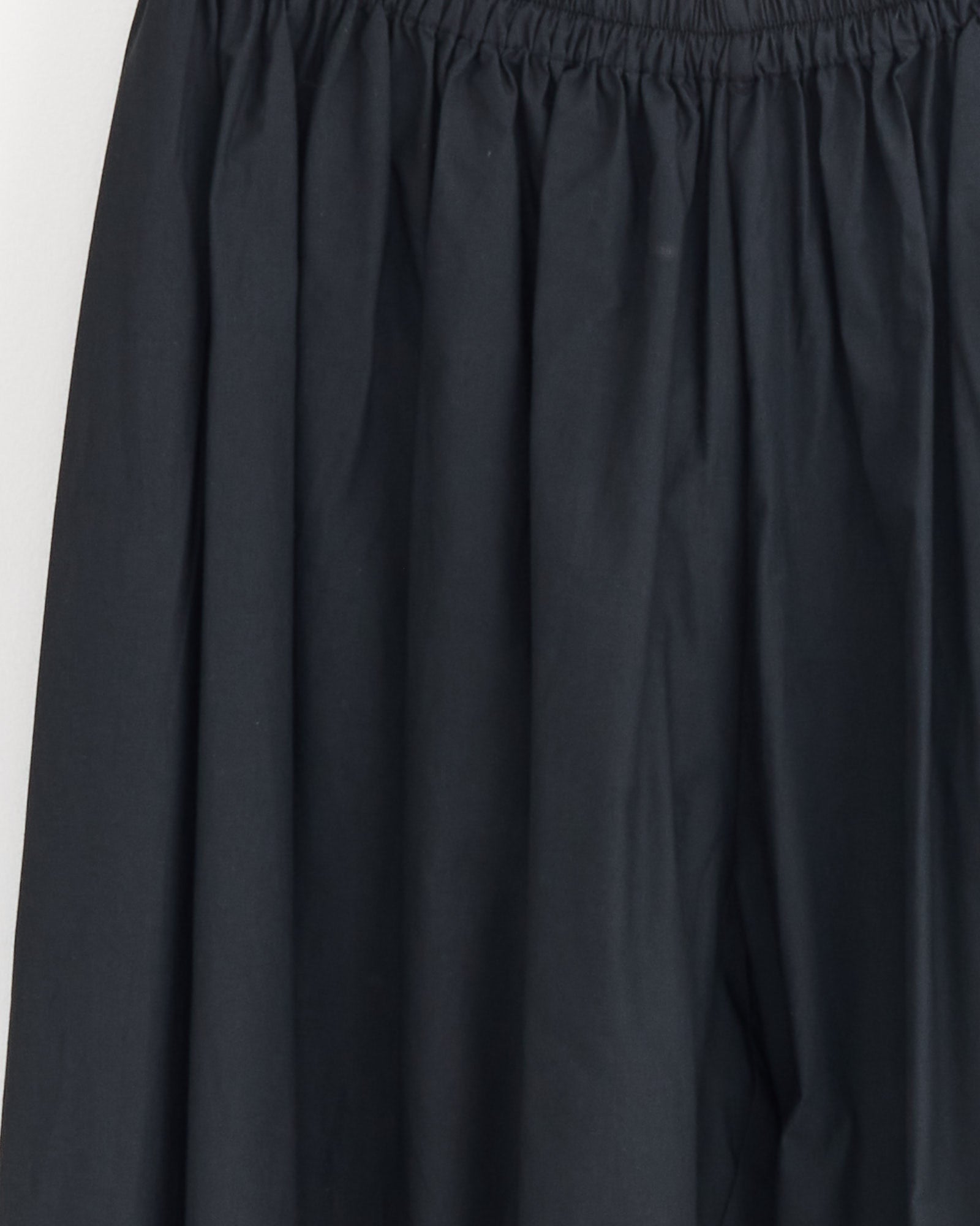 Close-up of the Baserange Simmon Pant in Black, featuring an elastic waistband with gathered and pleated detailing for a relaxed and comfortable fit.