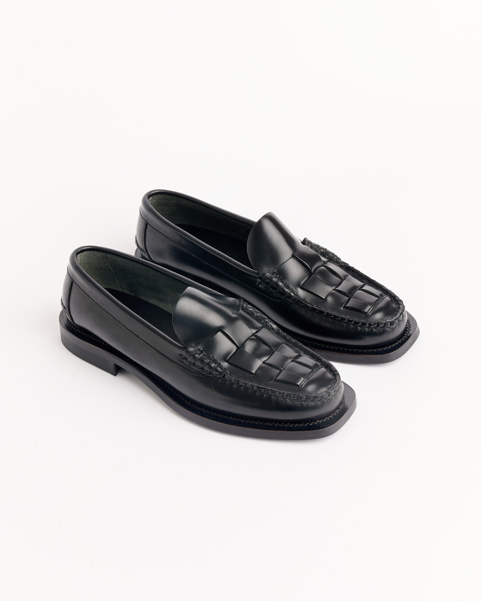 The Hereu Nombela Loafer in Black features woven leather detailing on the front and is displayed on a white background. For sizing and fit assistance, connect with our online chat.