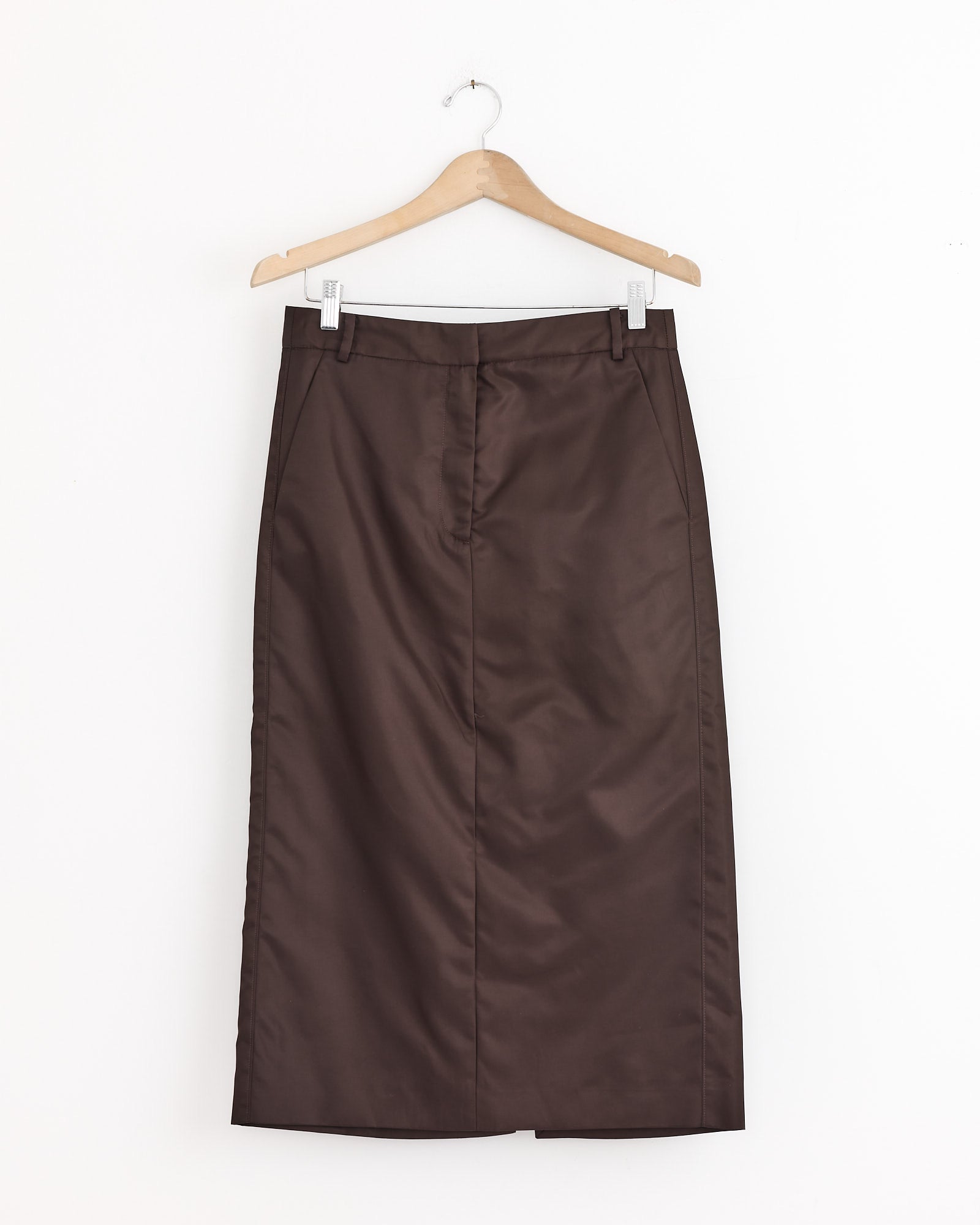 The Tibi Eco Nylon Midi Trouser in Skirt Brown, a utility-inspired brown skirt, is displayed on a wooden hanger against a plain white background.