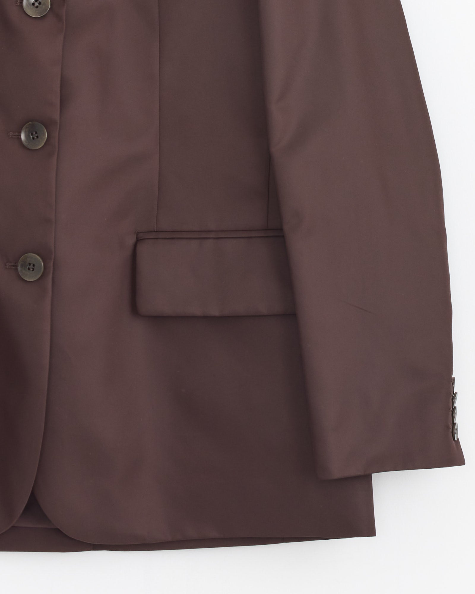 A close-up of the Tibi Eco Nylon Max Blazer in Brown showcases its buttons, flap pocket, and sleeve details against a white background.