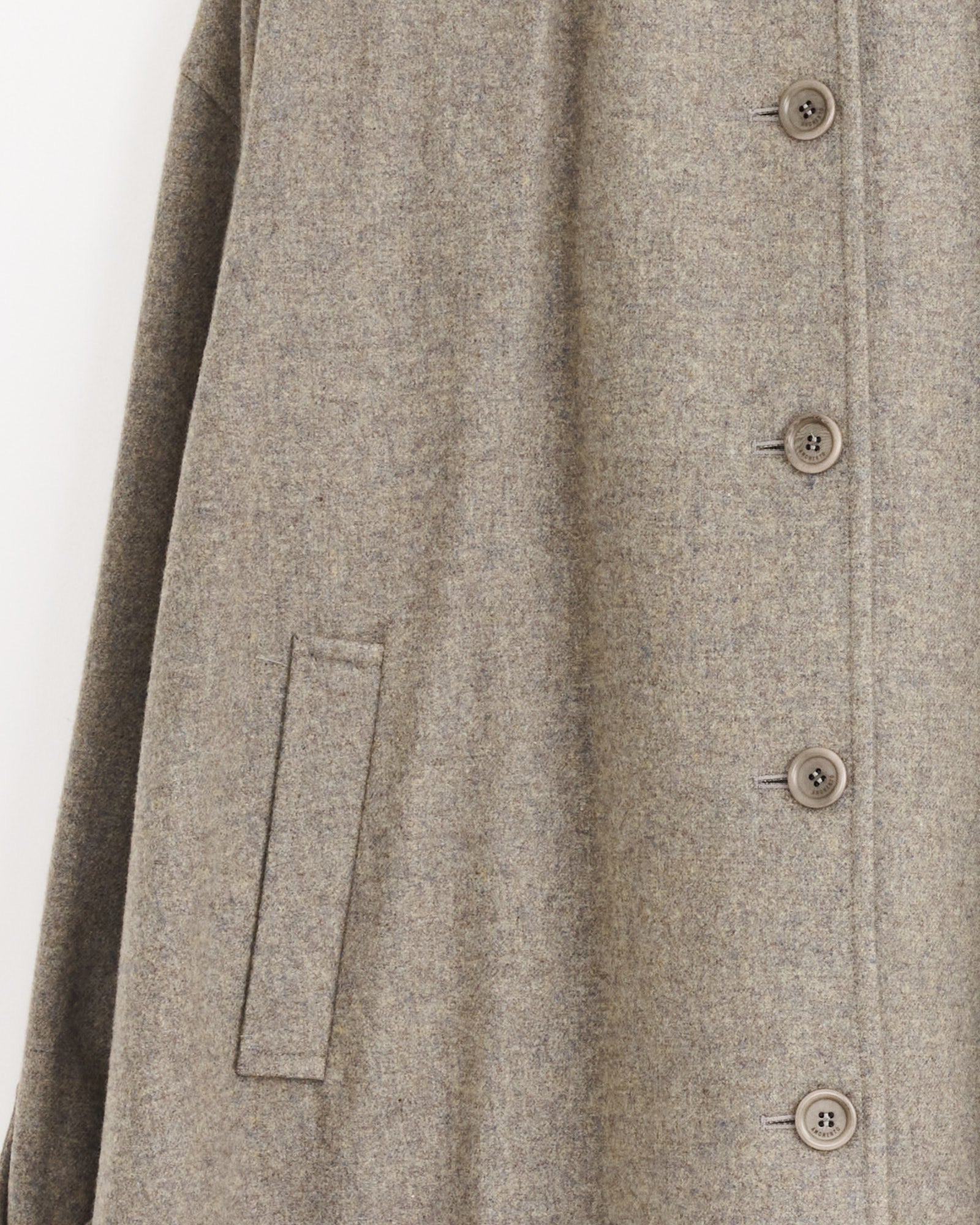 Close-up of the Amomento Shirring Coat in Grey Blue, showcasing a vertical line of brown buttons and a single left-side slit pocket. The wool-blend fabric appears soft and textured.