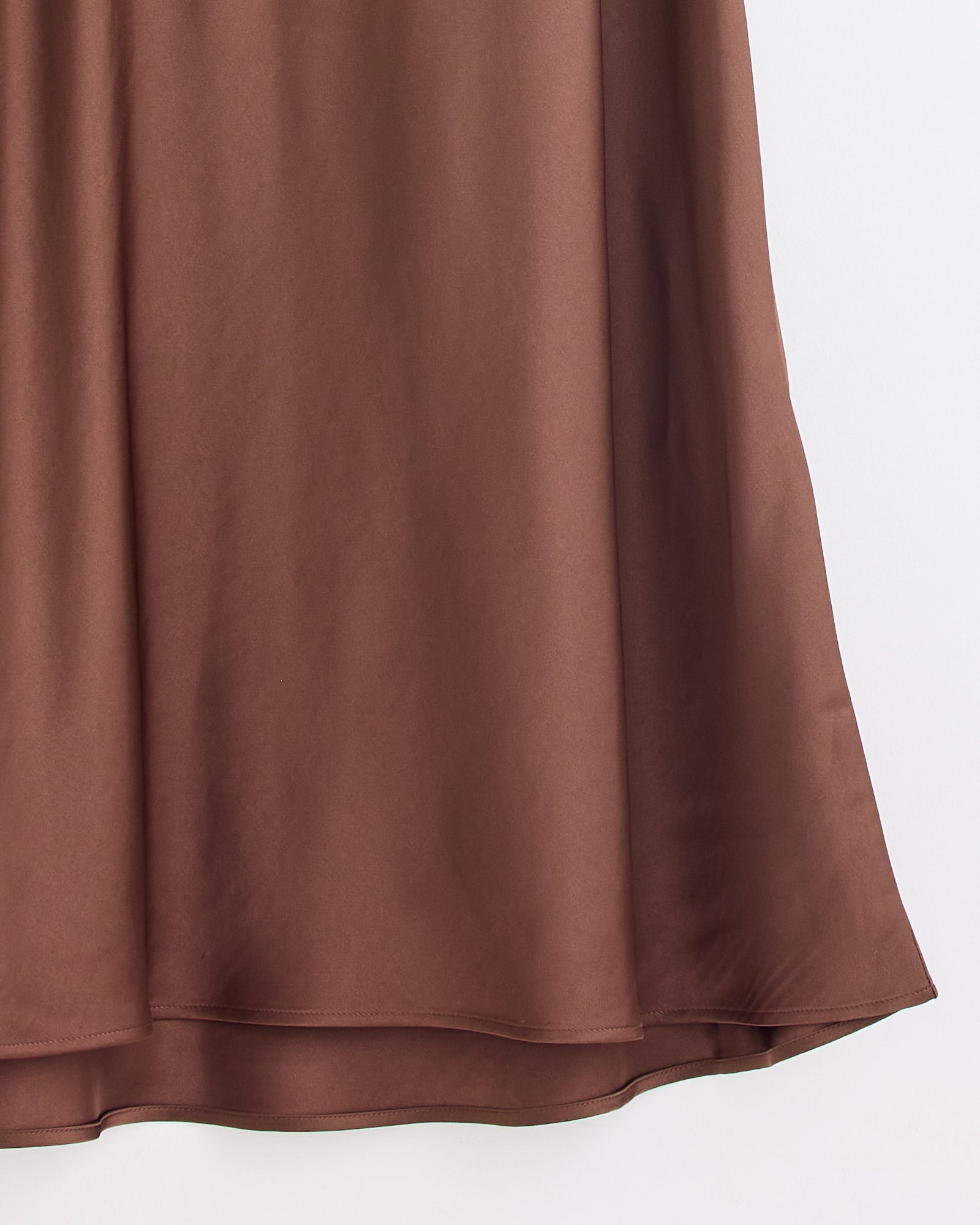 A close-up of the Boshan Skirt in Carafe by By Malene Birger, a brown satin midi A-line skirt with a smooth, subtly shiny texture, pictured against a plain white background.